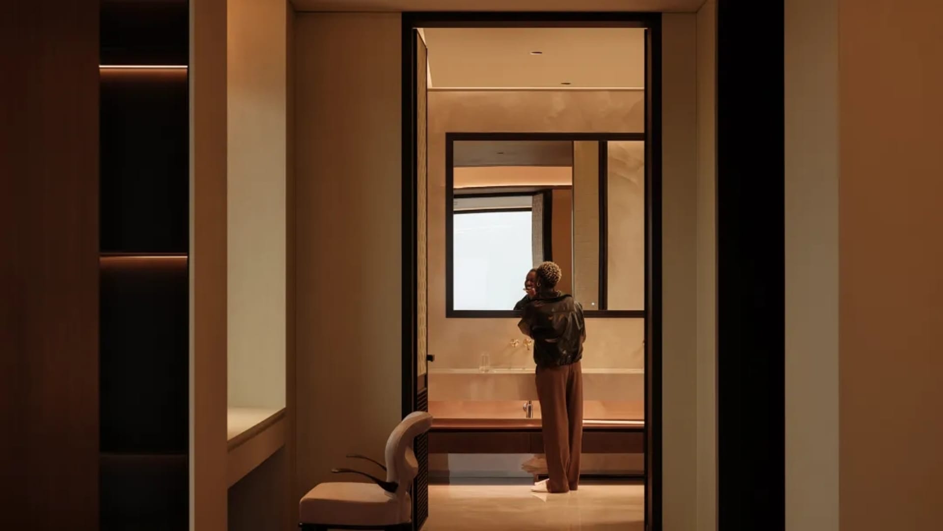 A minimalist modern bathroom with metallic surfaces and sleek, simple design.