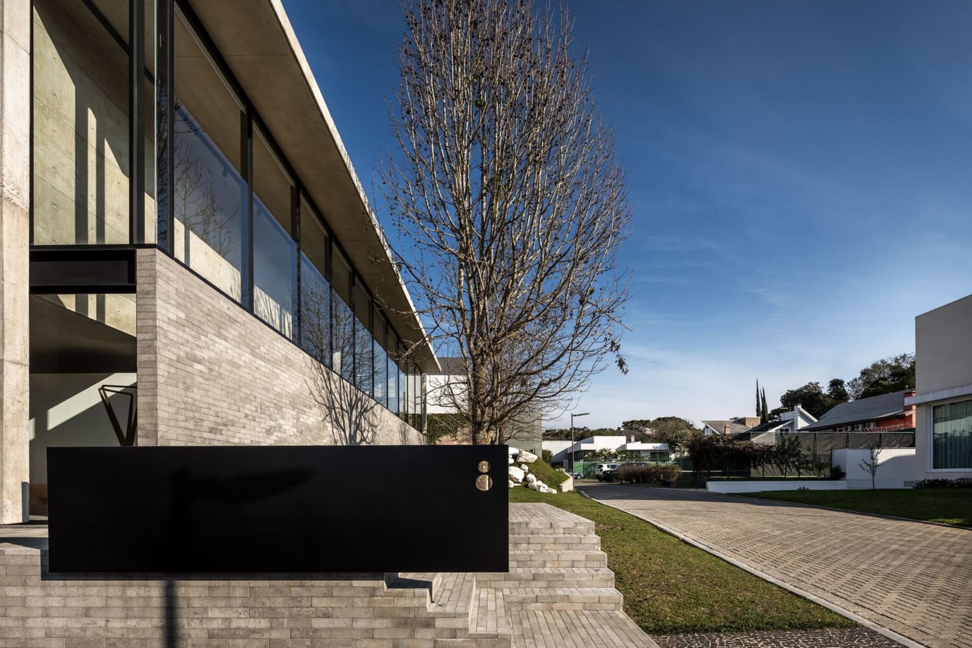 Modern building exterior with large glass windows and concrete structure.