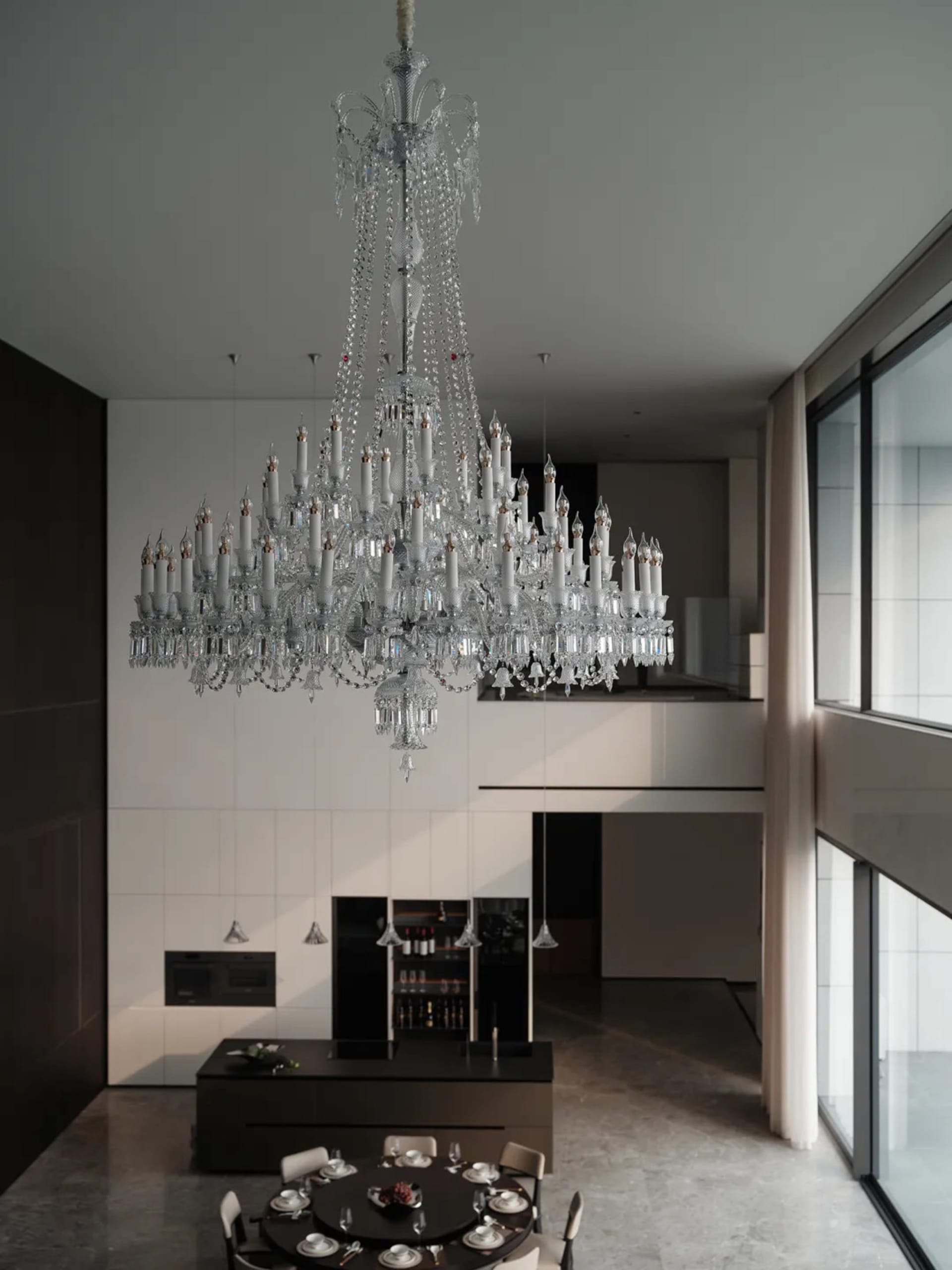 A modern, stylish dining room with a crystal chandelier hanging from the ceiling.
