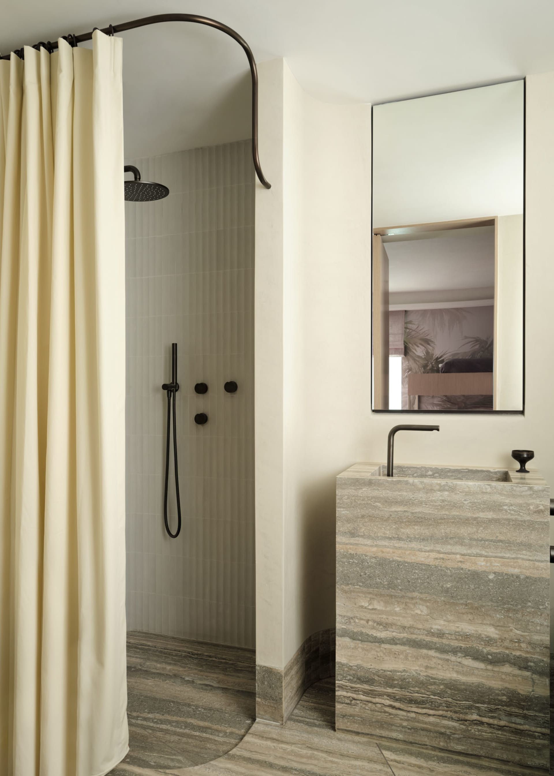 Modern bathroom with marble floor, sink, and shower area enclosed by a beige curtain.