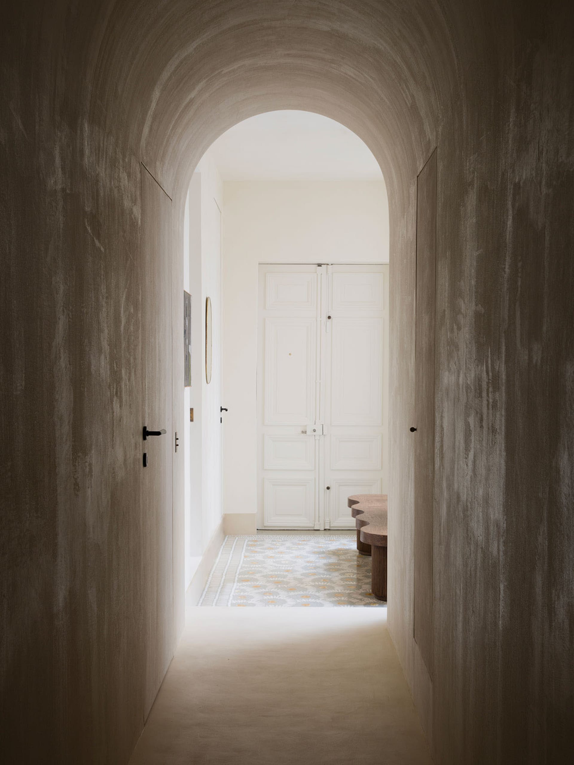 An image of a modern hallway featuring an architectural concrete archway.