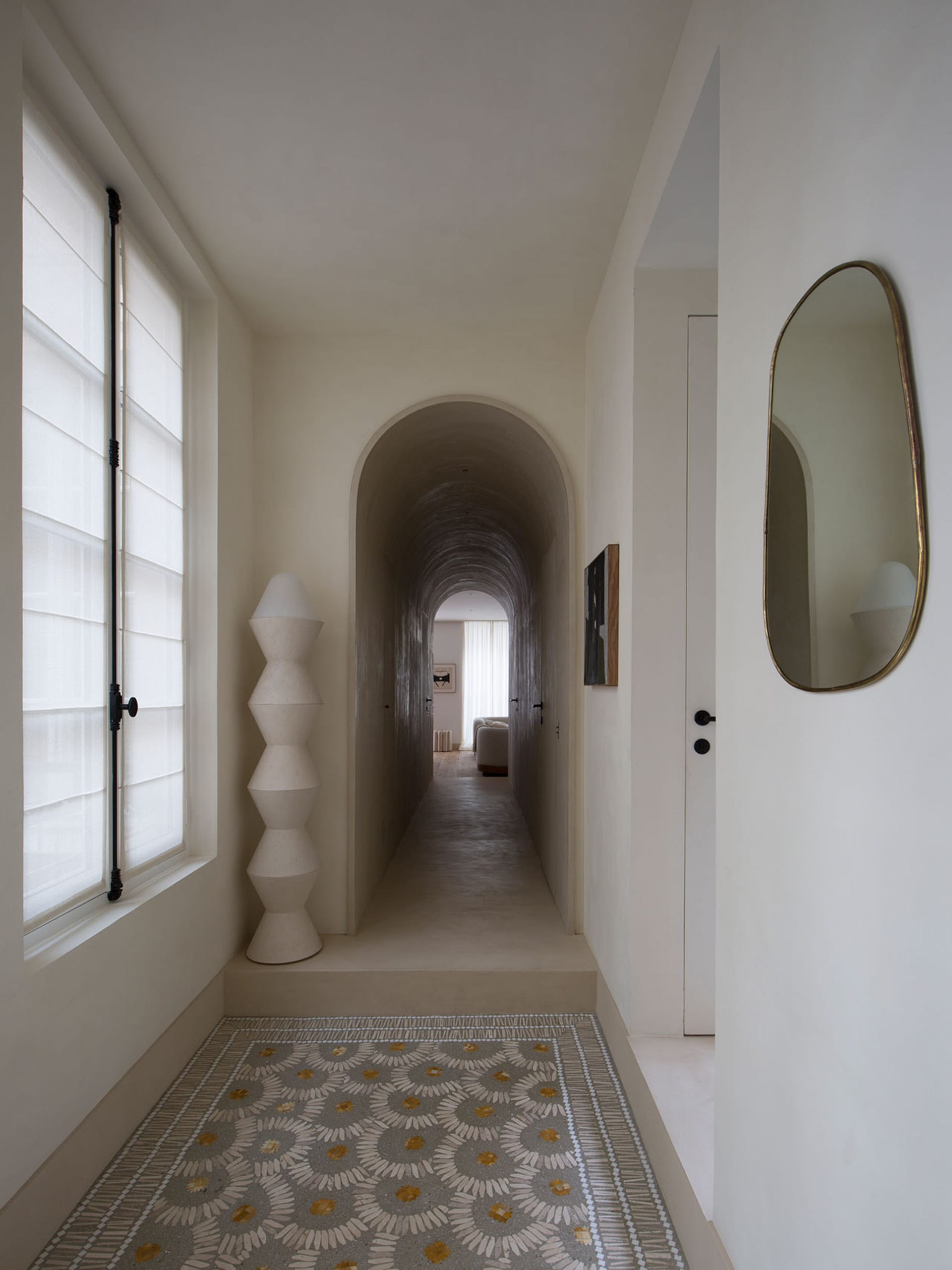 Modern minimalist hallway with concrete walls and tiled floor.