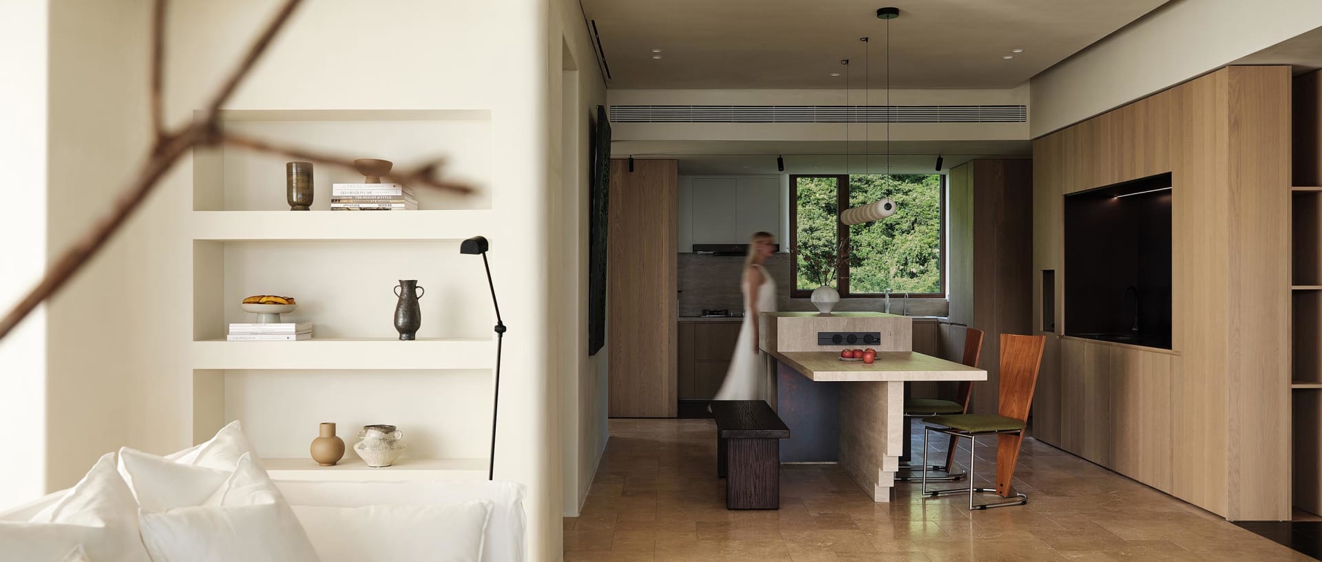 Modern living and dining room with marble counter and wooden furniture, showcasing a contemporary design aesthetic.