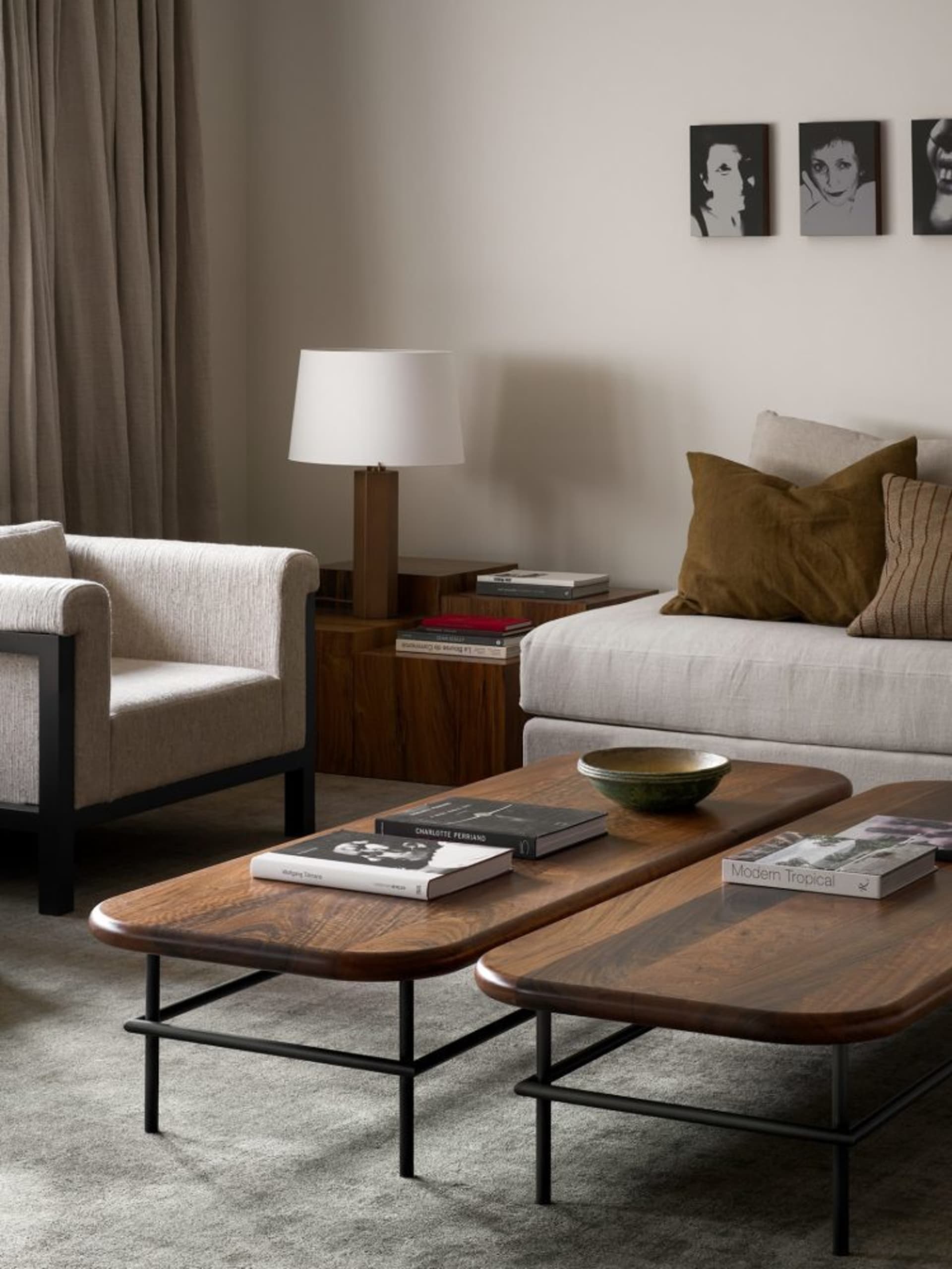 A modern living room with a wooden coffee table, metal legs, fabric couch, and armchair.