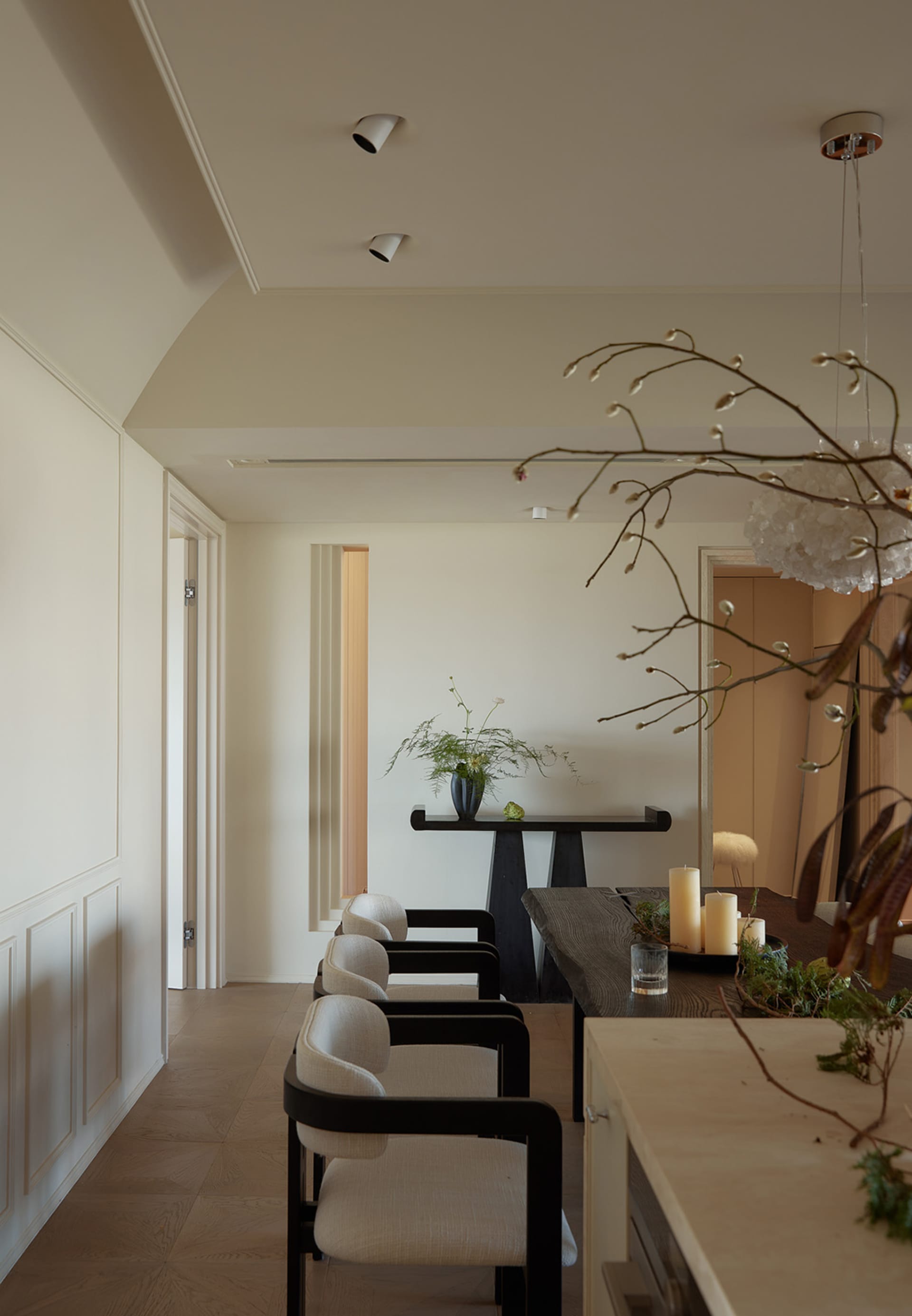 A minimalist dining room with wooden furniture and white walls.