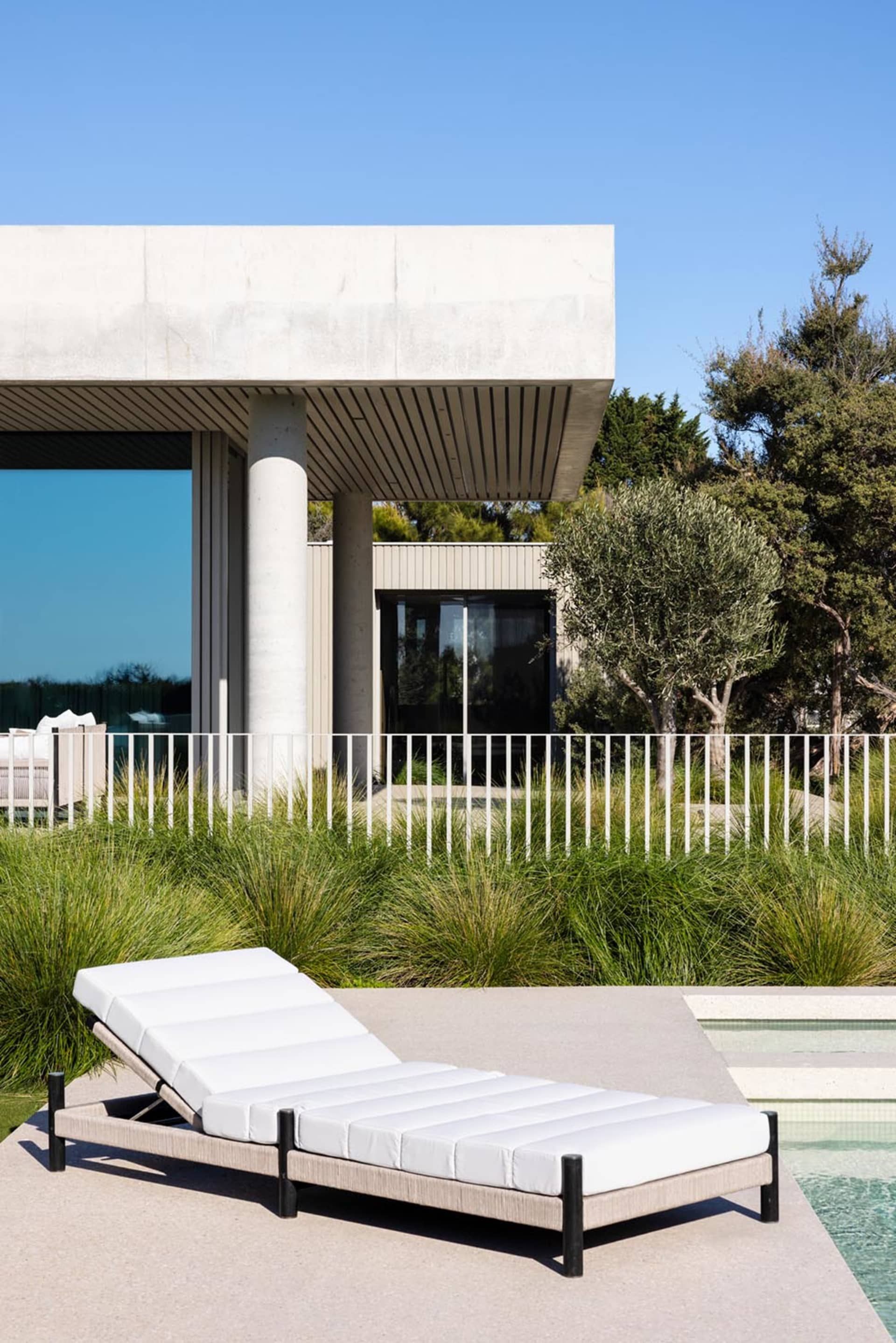 A modern outdoor space featuring a concrete and glass architectural design.