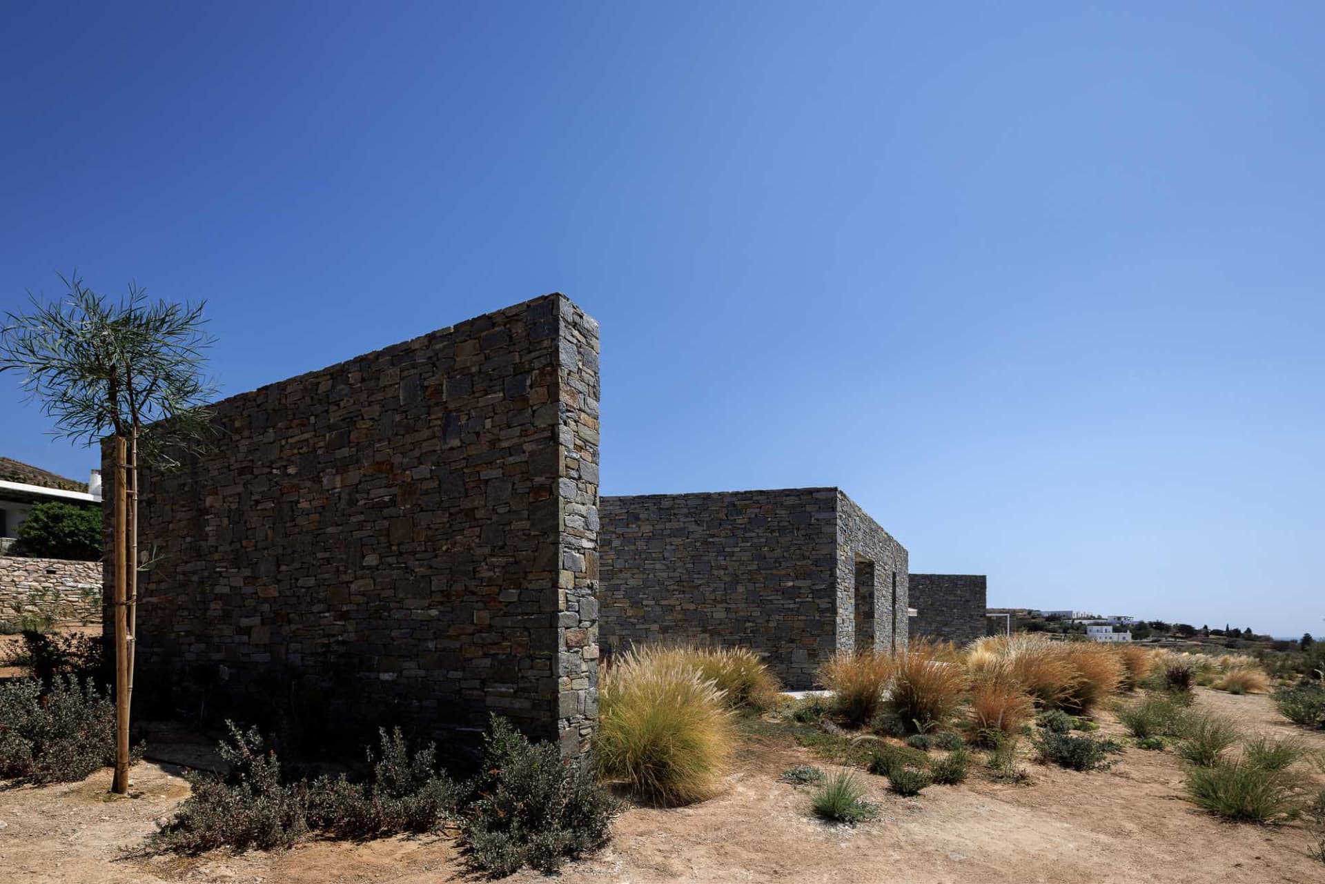 Modern house featuring a stone exterior against a clear blue sky。