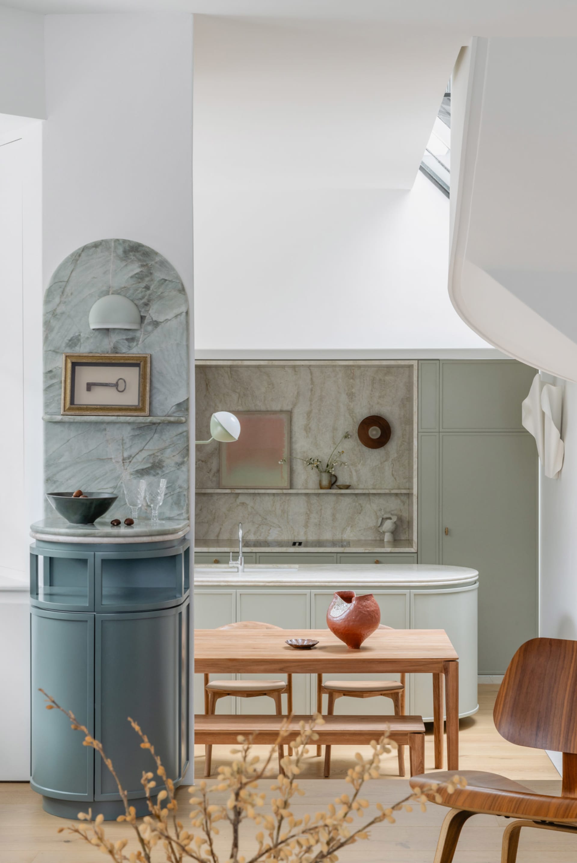 Modern living, dining, and kitchen space featuring marble countertops, wooden furniture, and ceramic ornaments.