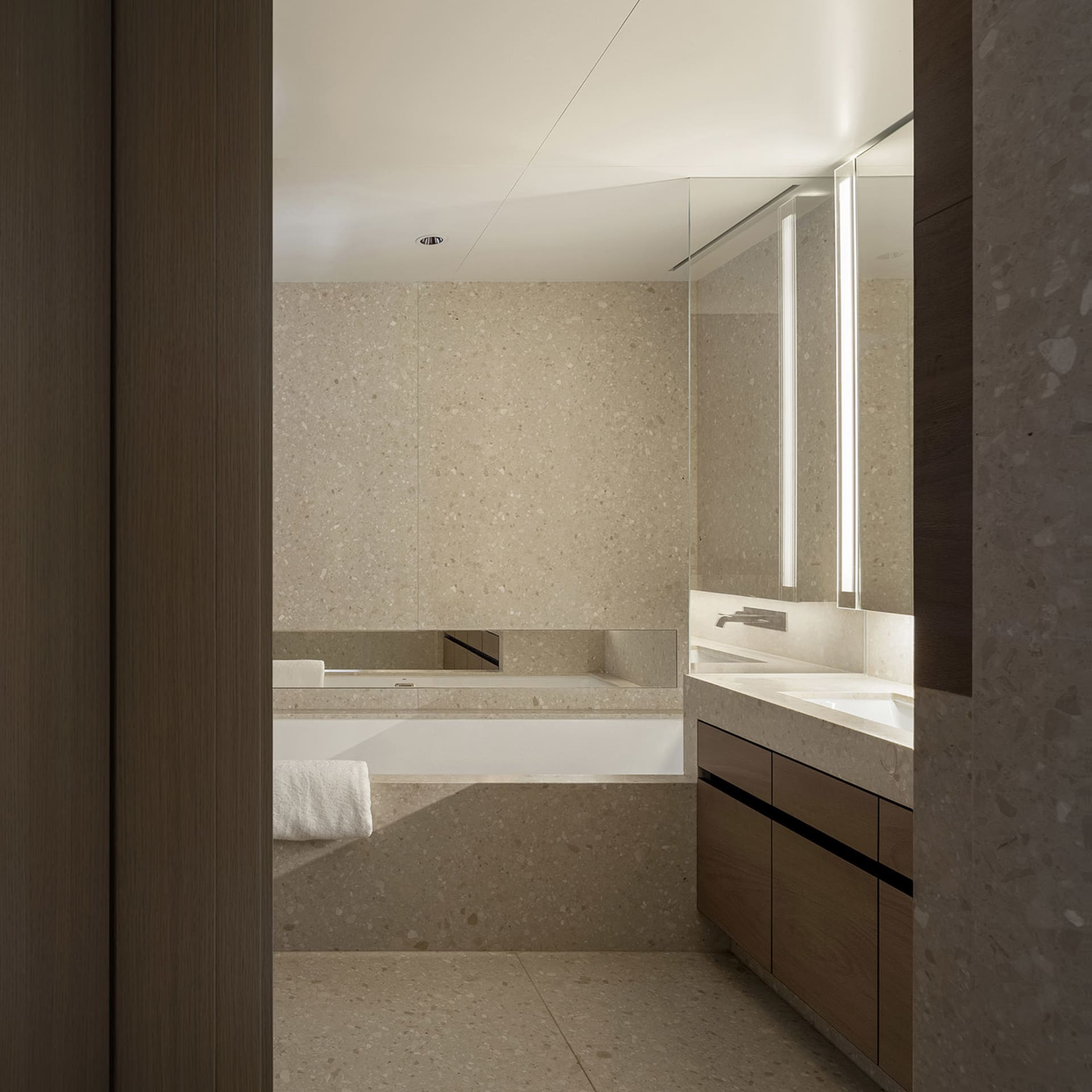 Modern bathroom featuring a terrazzo countertop and ceiling-mounted mirror.