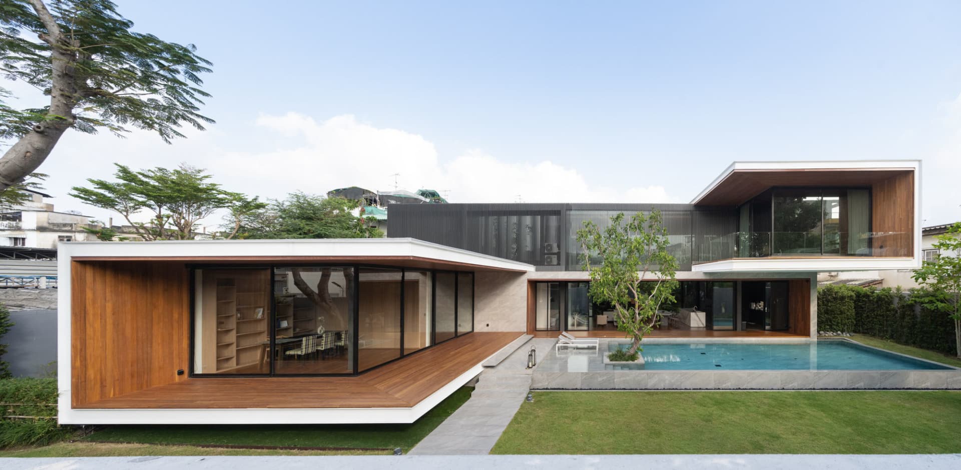 Modern residential exterior featuring wood, glass, and stone materials