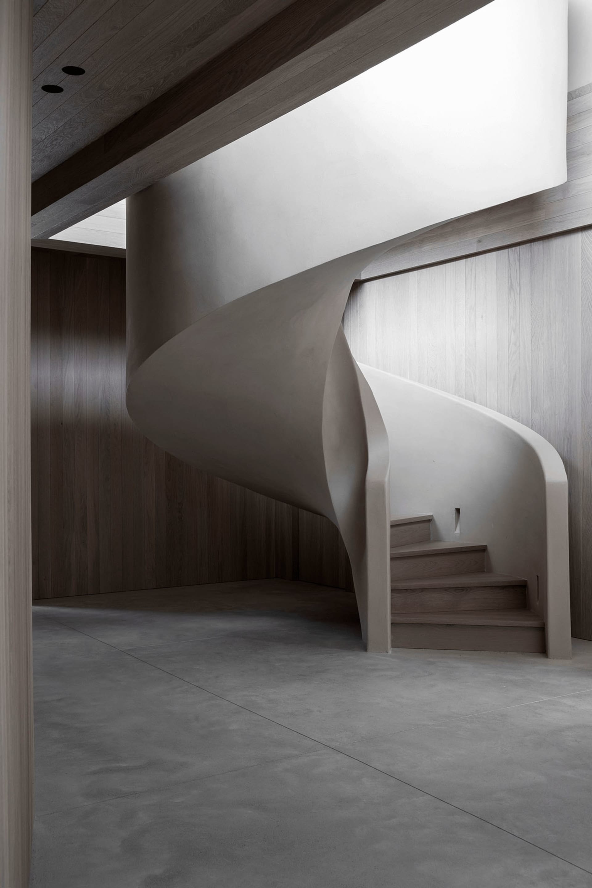Modern, sleek, concrete staircase with a fluid, curved design.