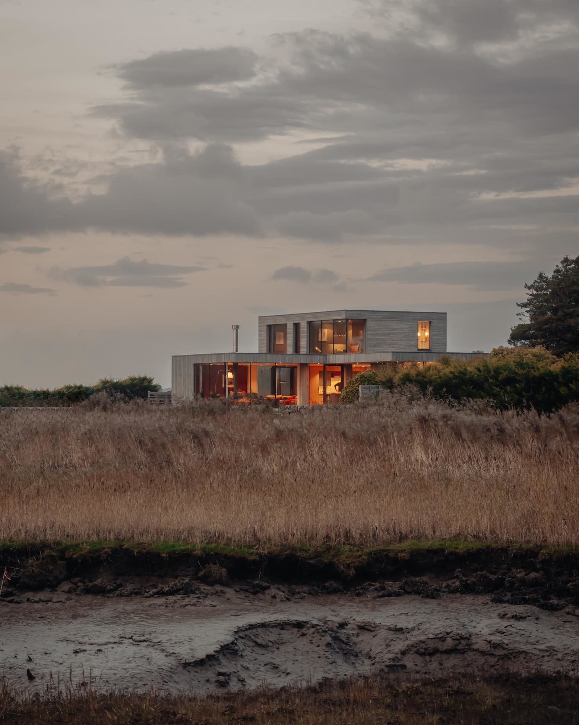 A modern residential house with a wooden exterior and large windows.