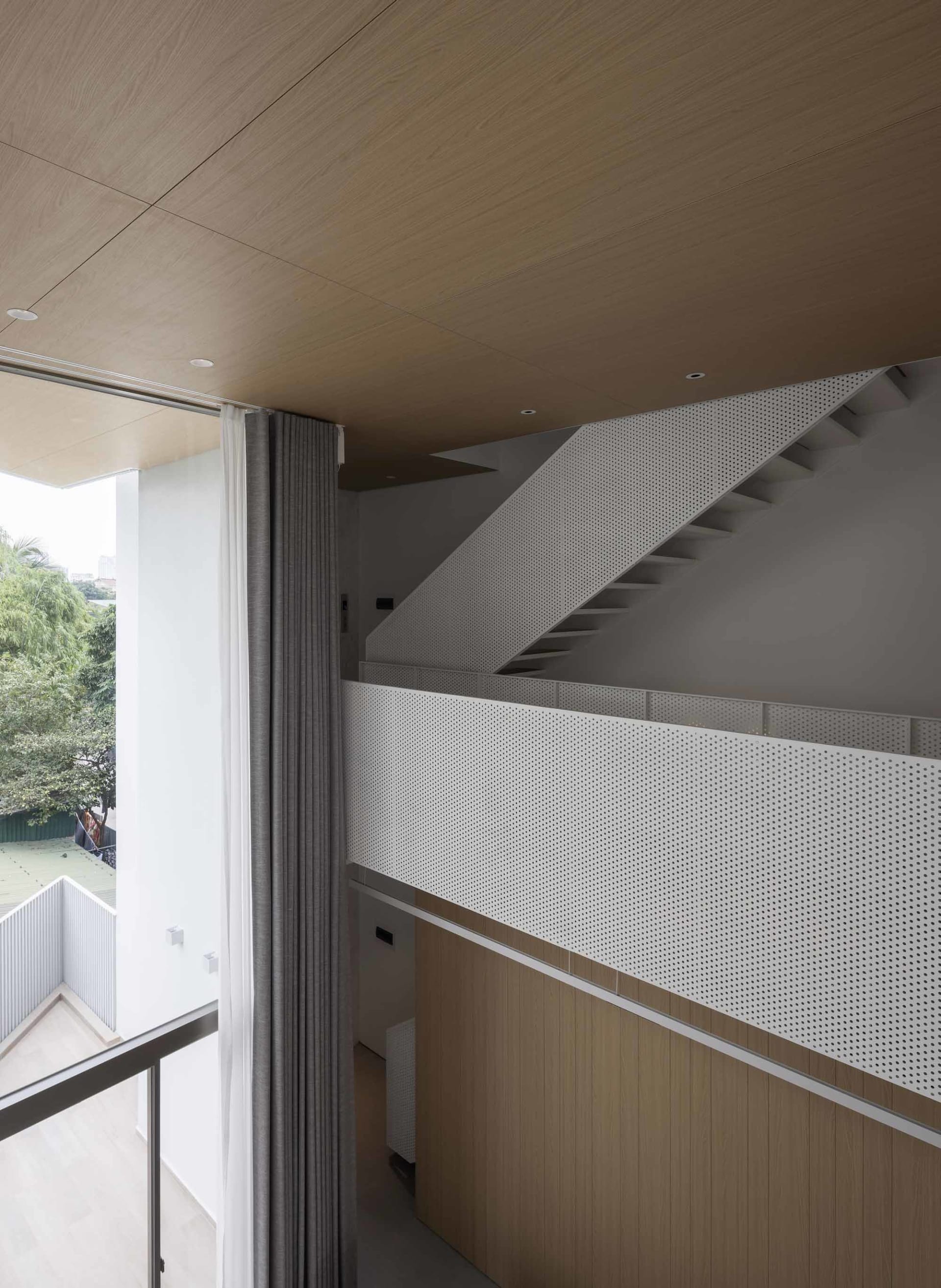 A modern interior space featuring metallic perforated panels and wooden elements.