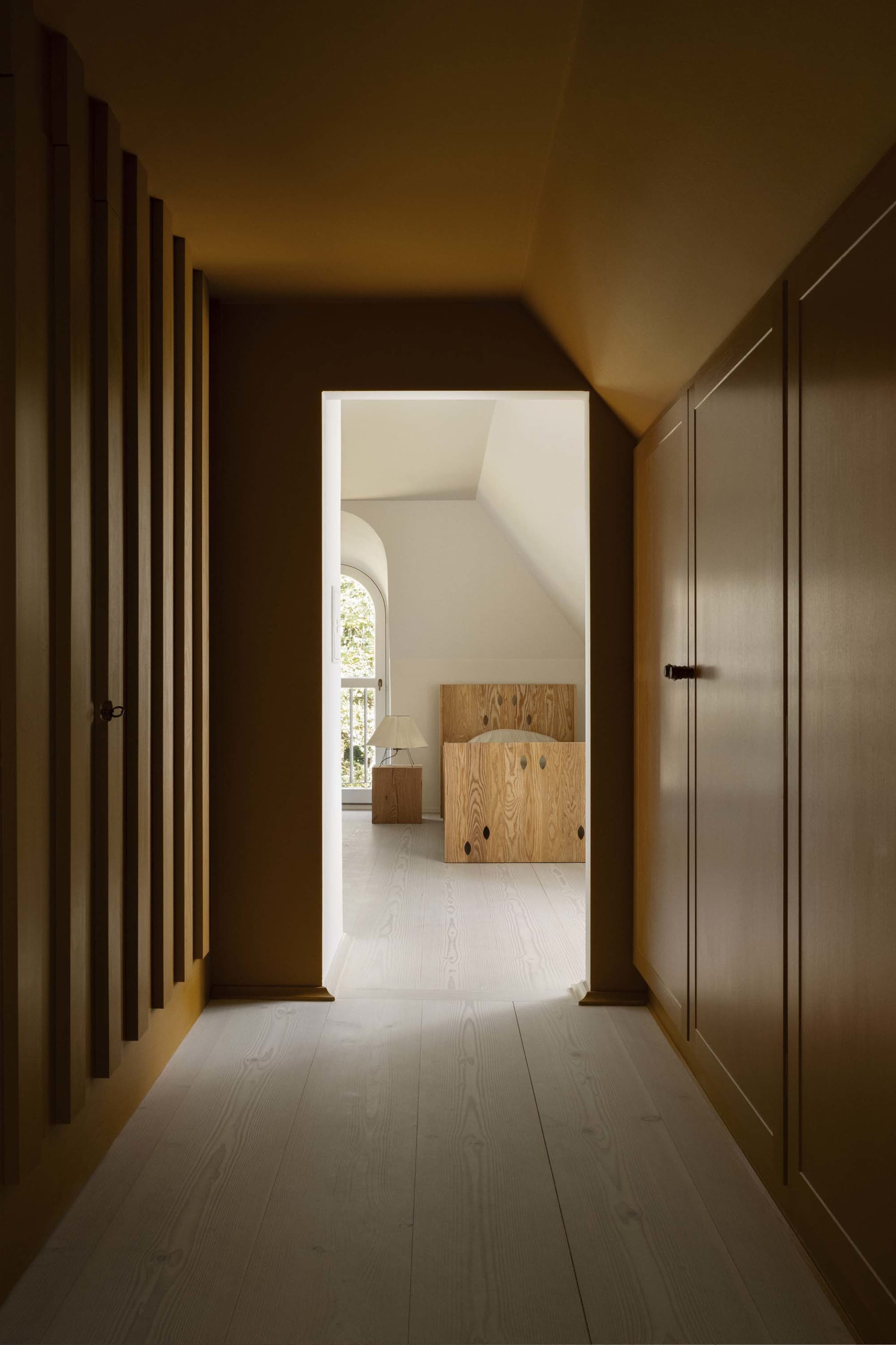 A modern interior space featuring wooden cabinets and white flooring.