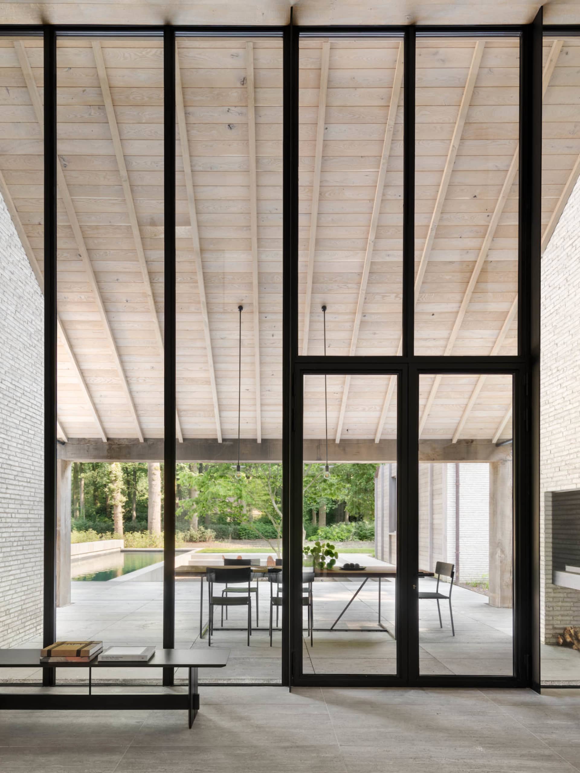 Contemporary indoor living space with modern furniture and large glass windows.