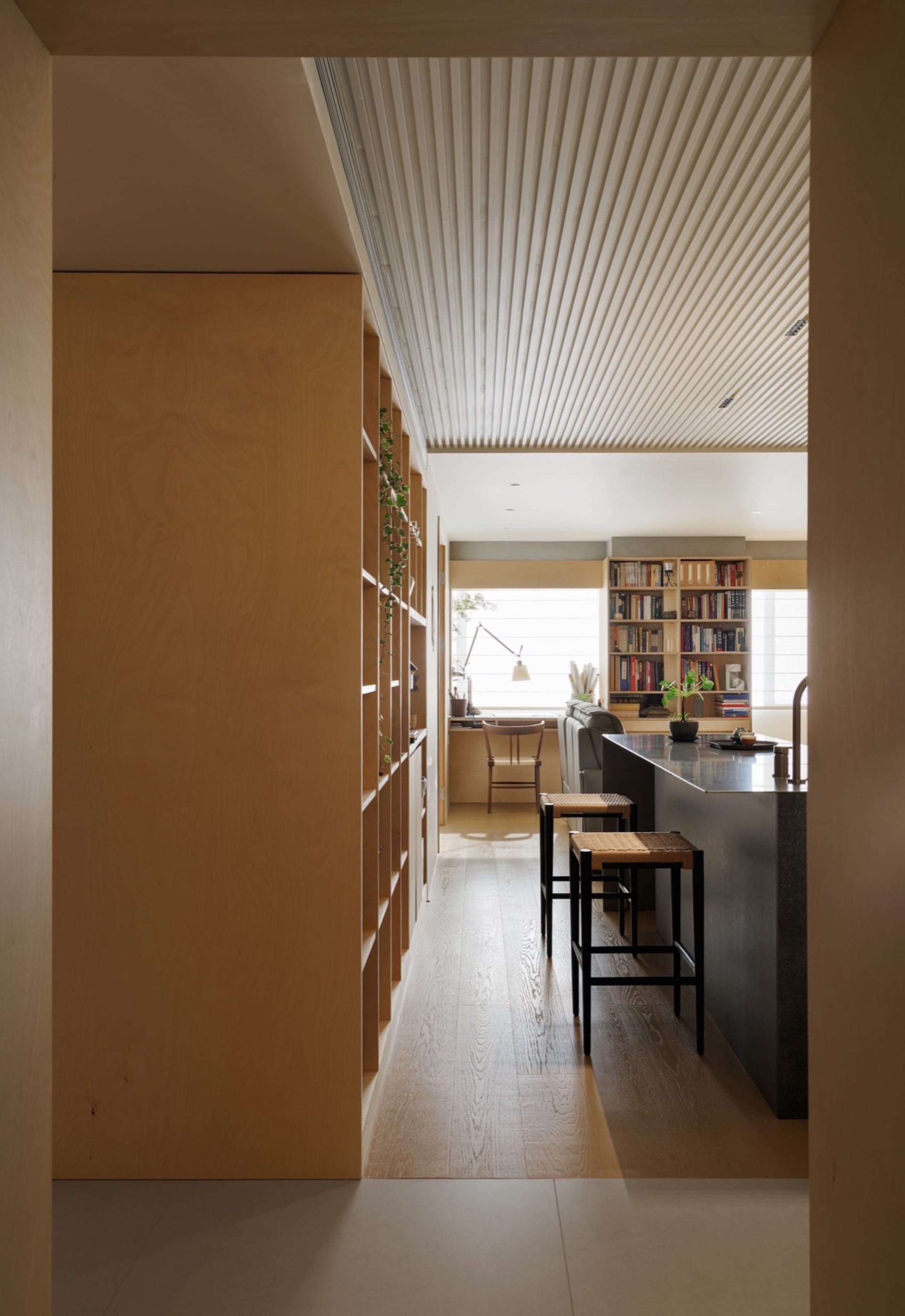 Minimalist modern kitchen featuring wooden cabinets and glass countertops, designed for efficiency and aesthetic appeal.