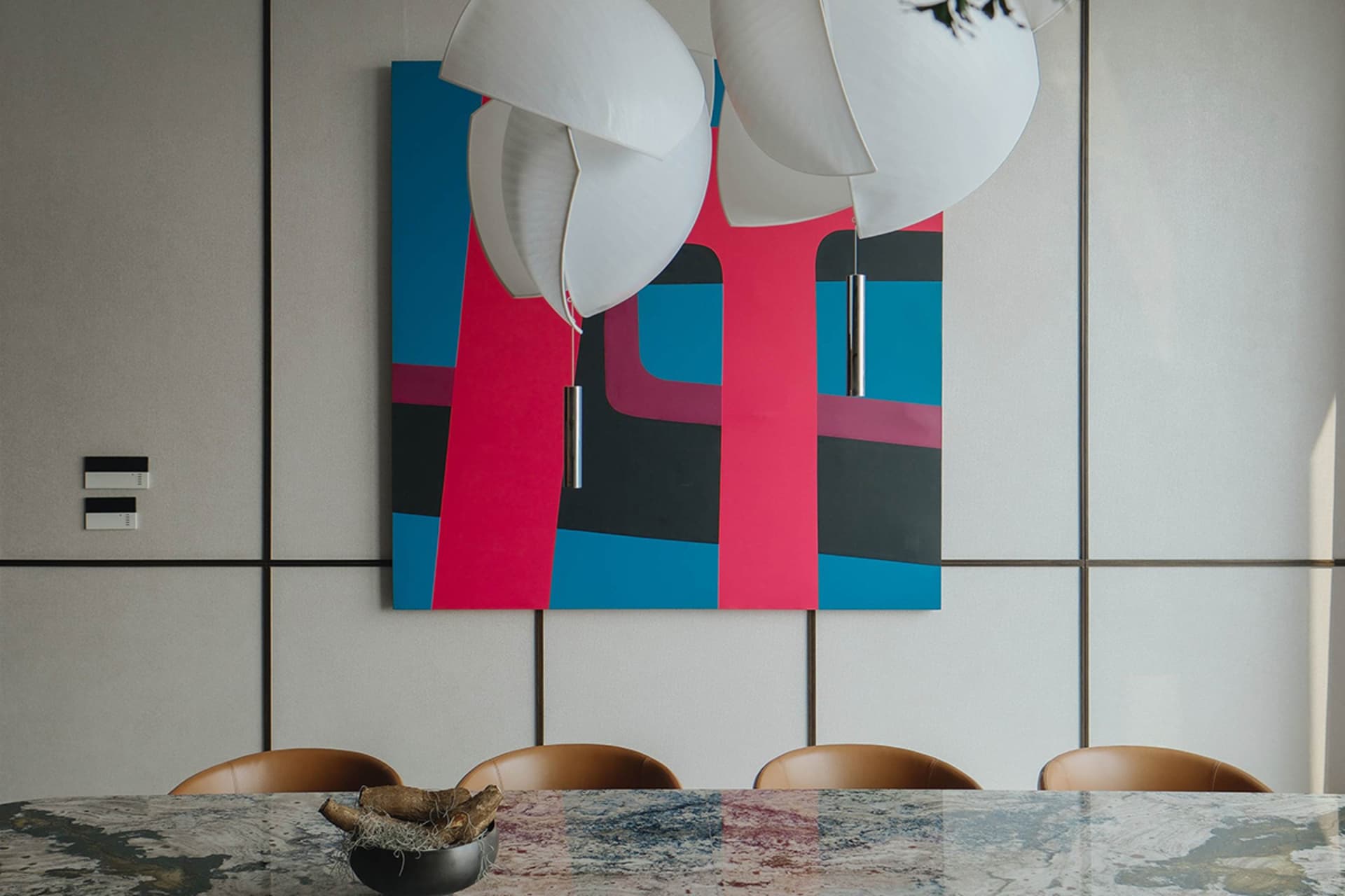 A modern dining room features a large, vibrant abstract painting as the centerpiece, accompanied by sleek, contemporary chair