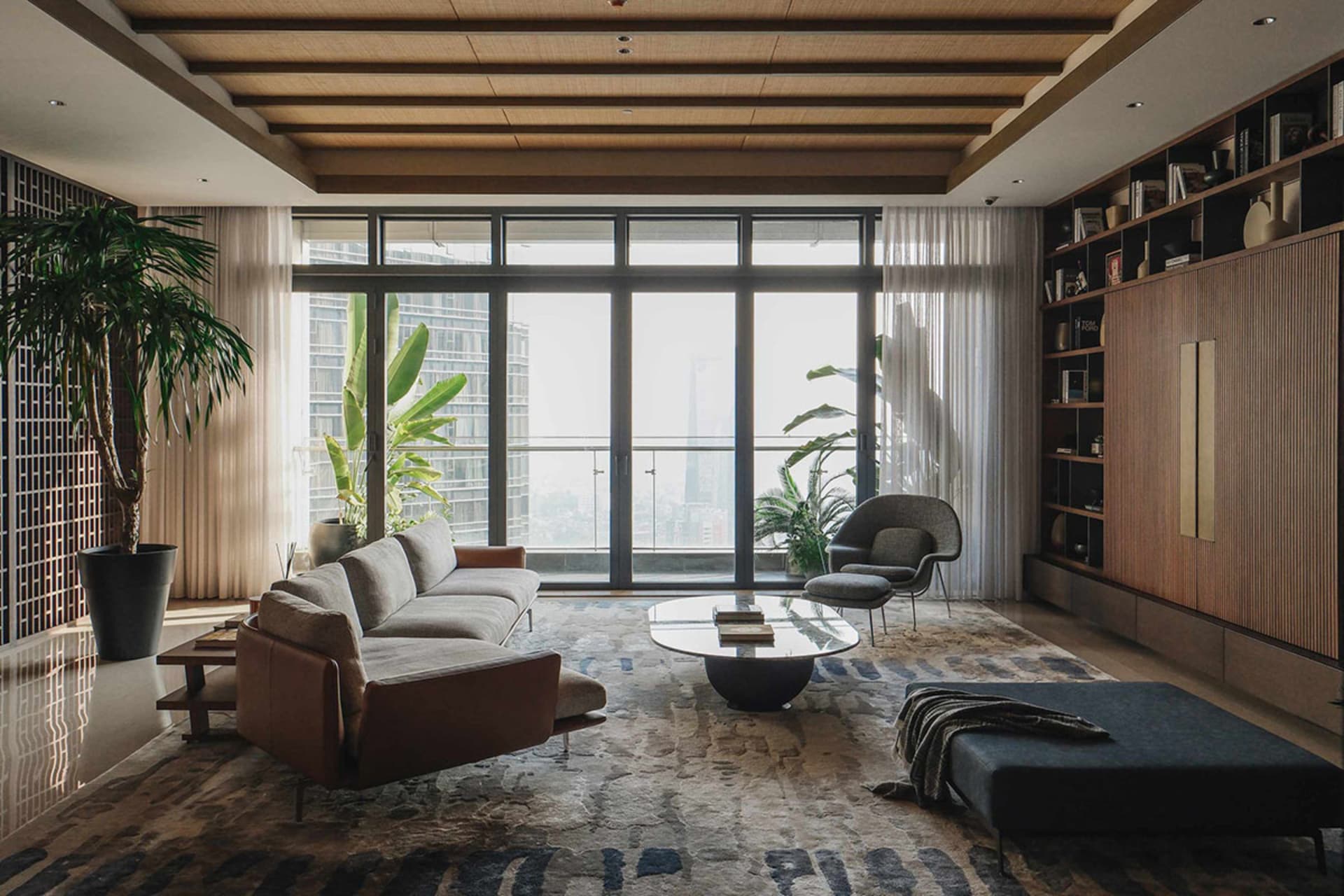 A modern living room featuring wooden furniture and a large window with city views.