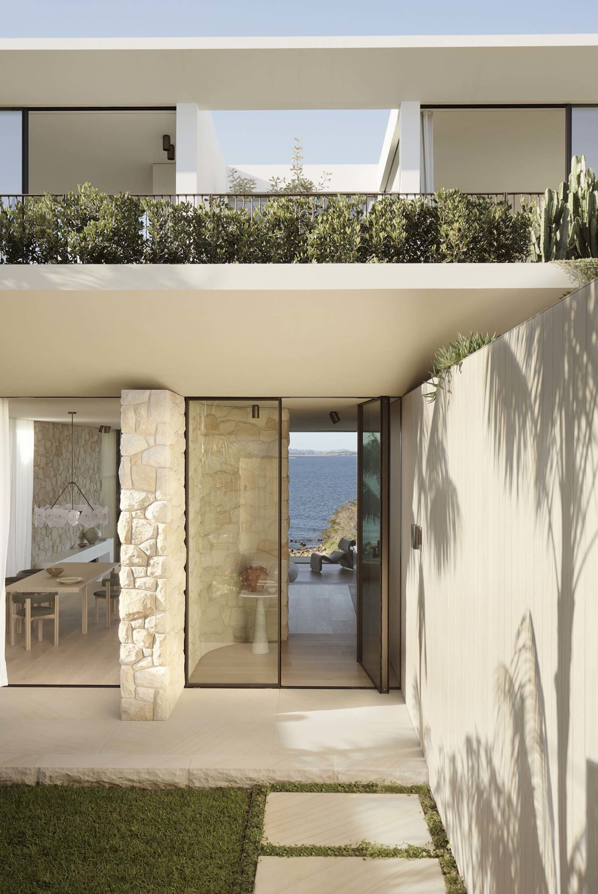 Modern residential exterior featuring stone, glass, and metal elements.