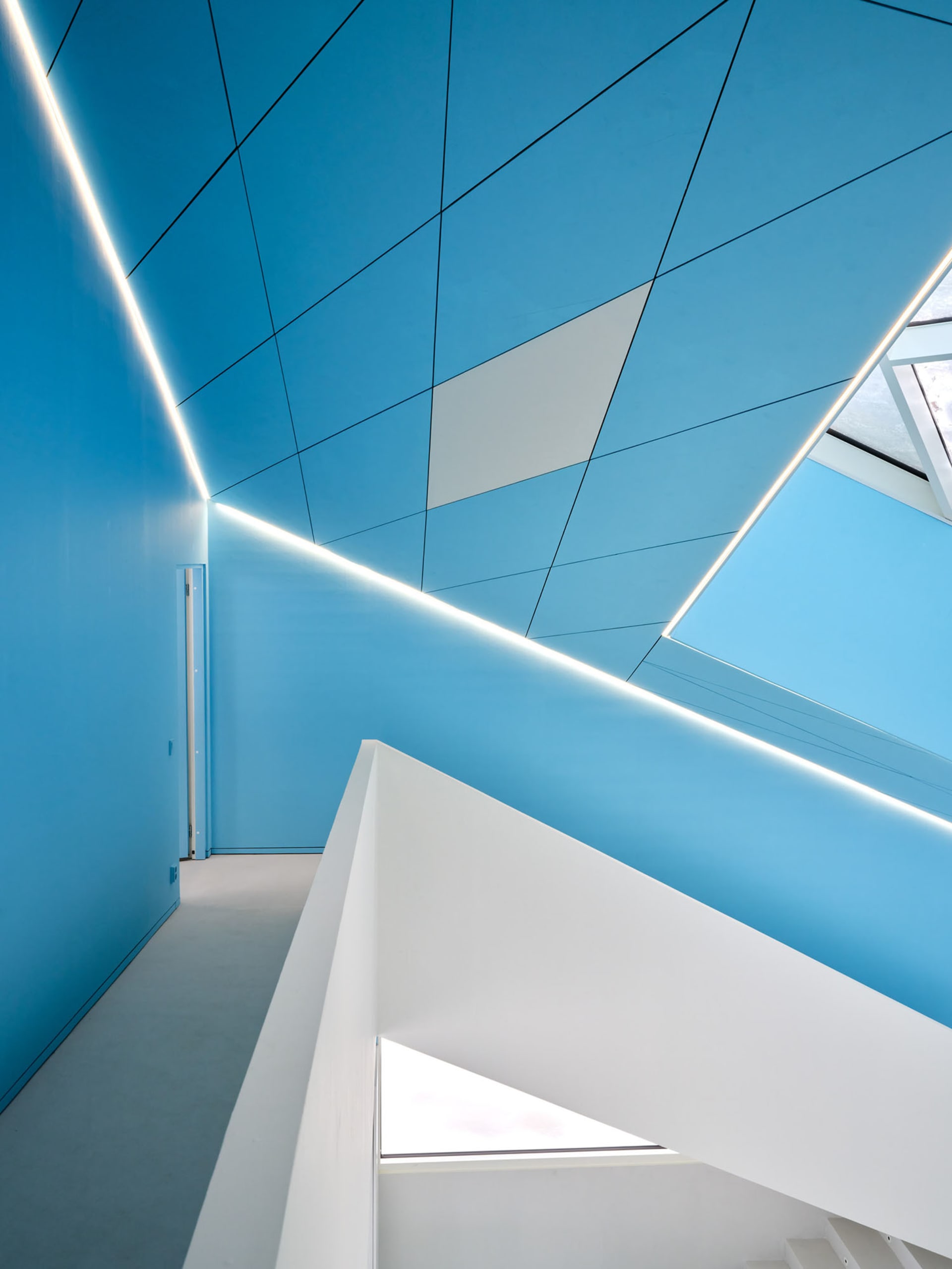 A modern interior design featuring blue walls and white accents.