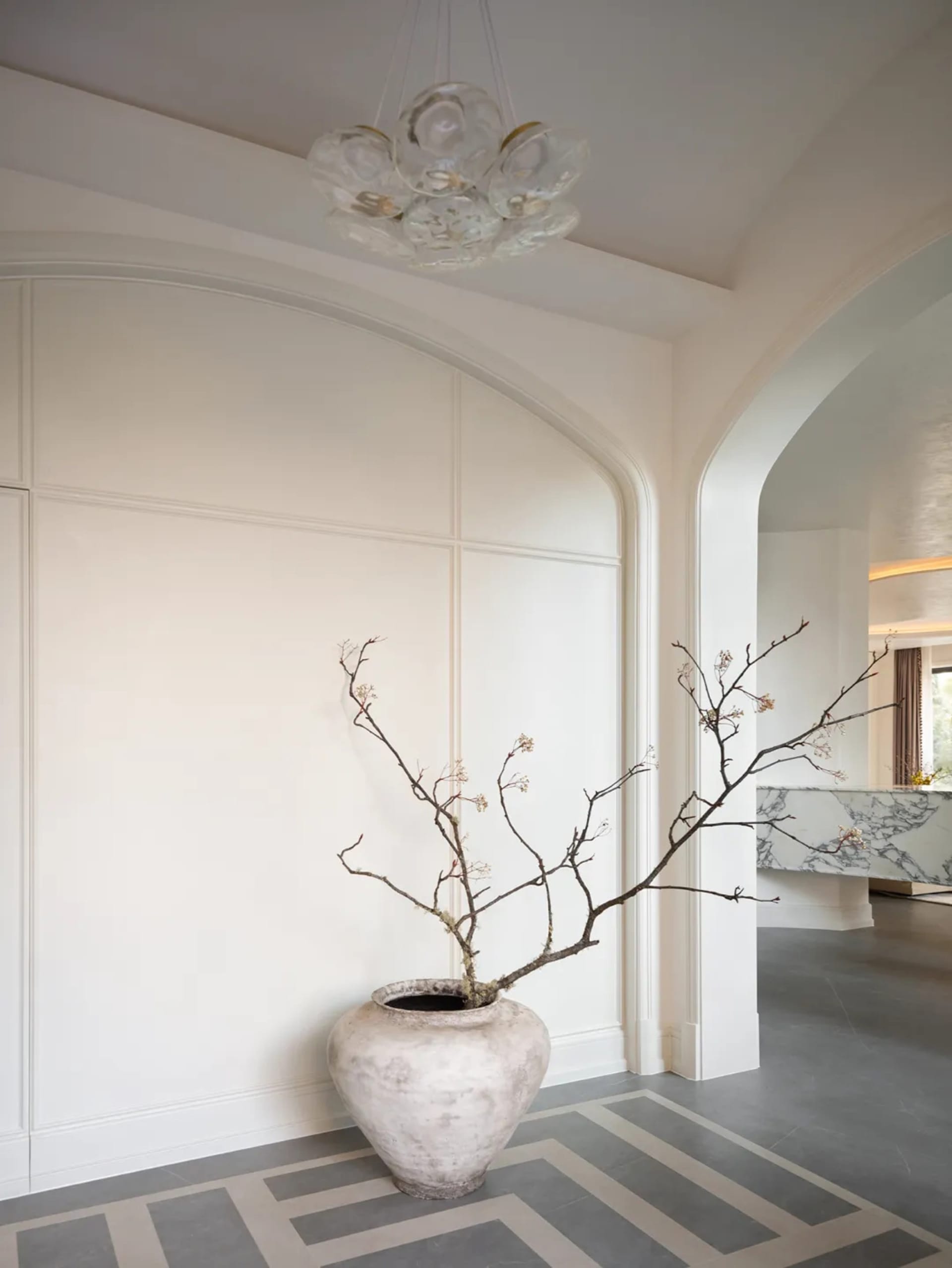 Modern lobby interior with white walls, concrete flooring, and a marble reception counter