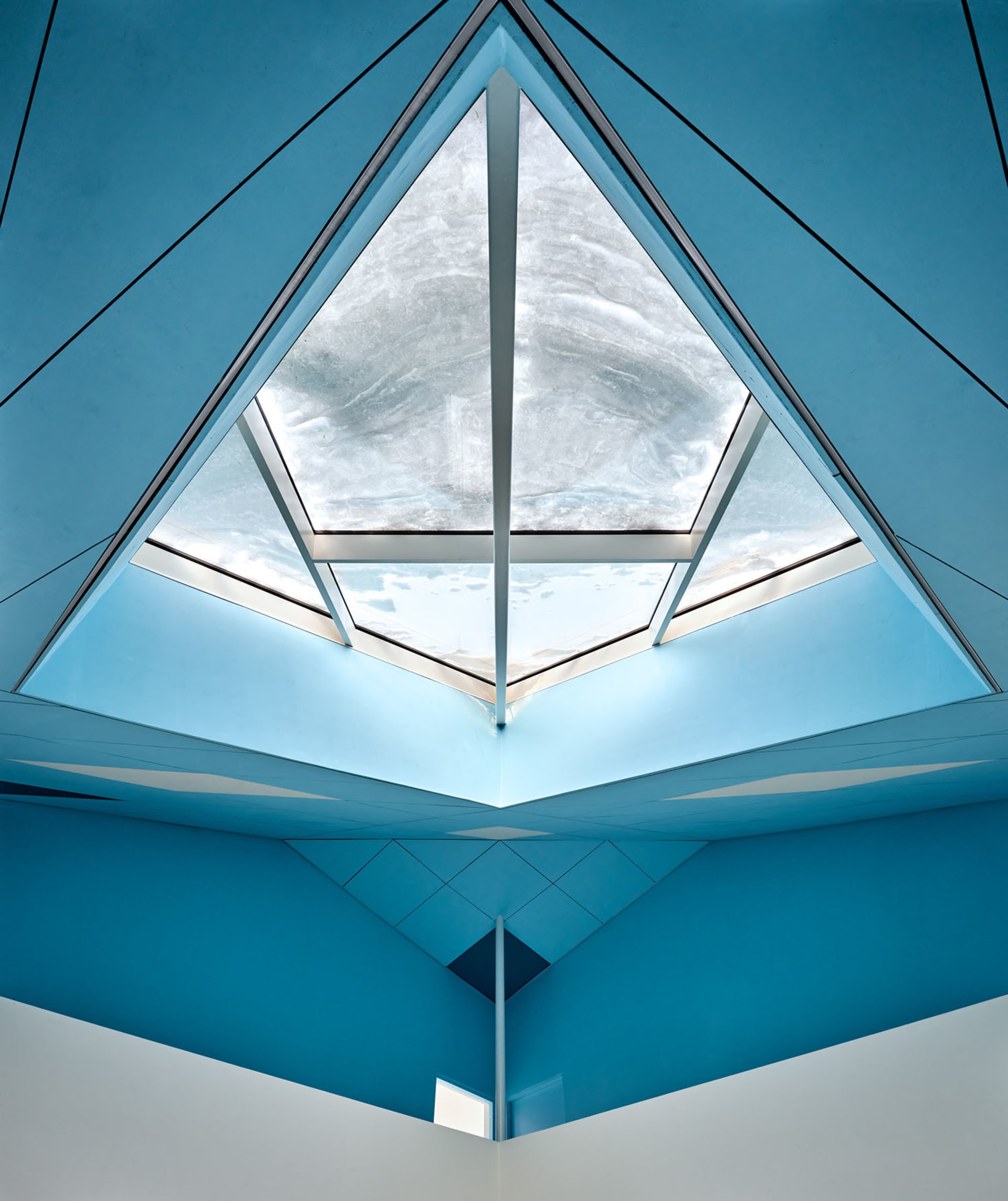 Interior view of a modern office with a glass ceiling showcasing sleek, contemporary design elements.