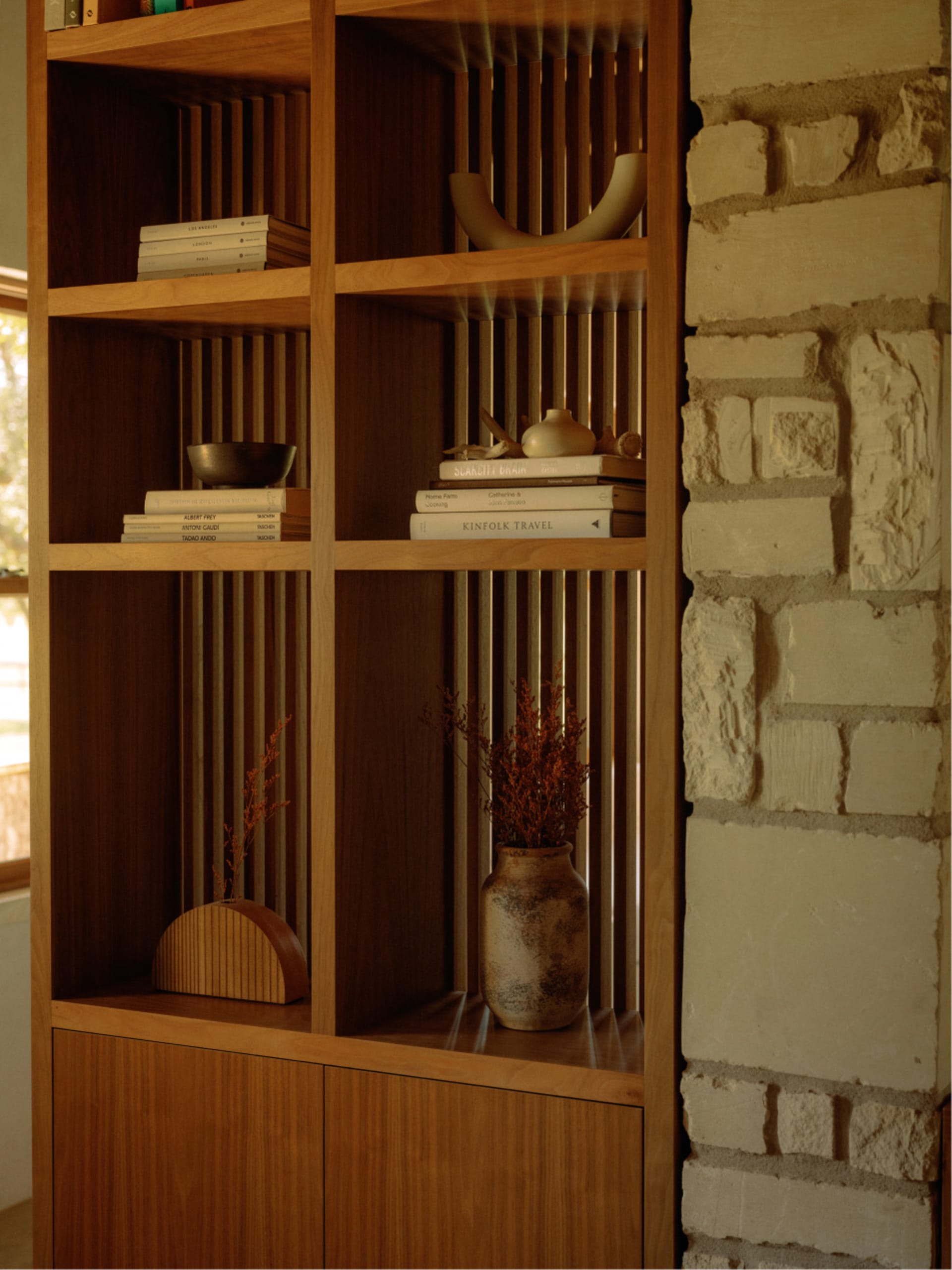 A modern wooden bookshelf with books and decorative items.
