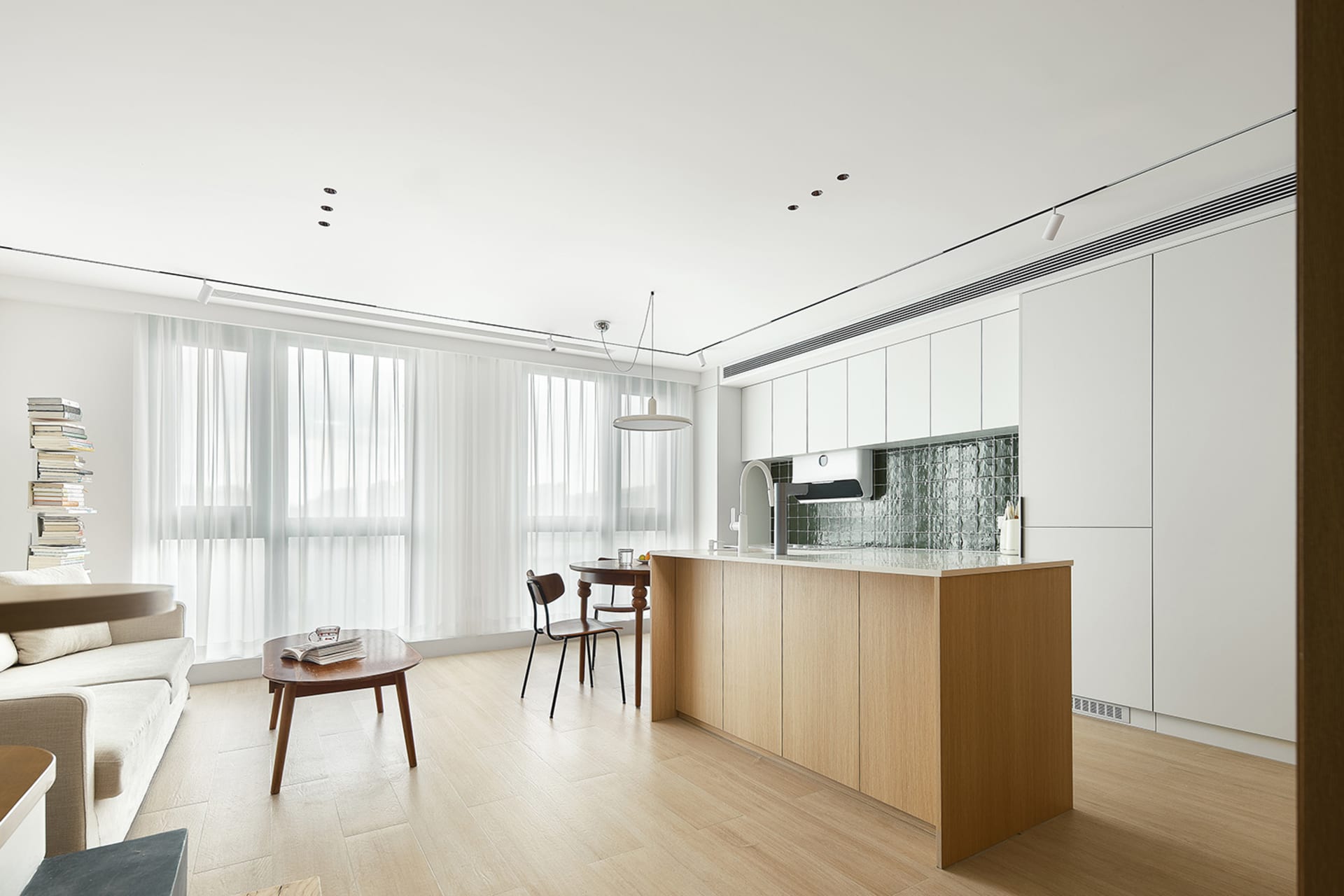 A modern minimalist kitchen with white cabinets and wooden accents.