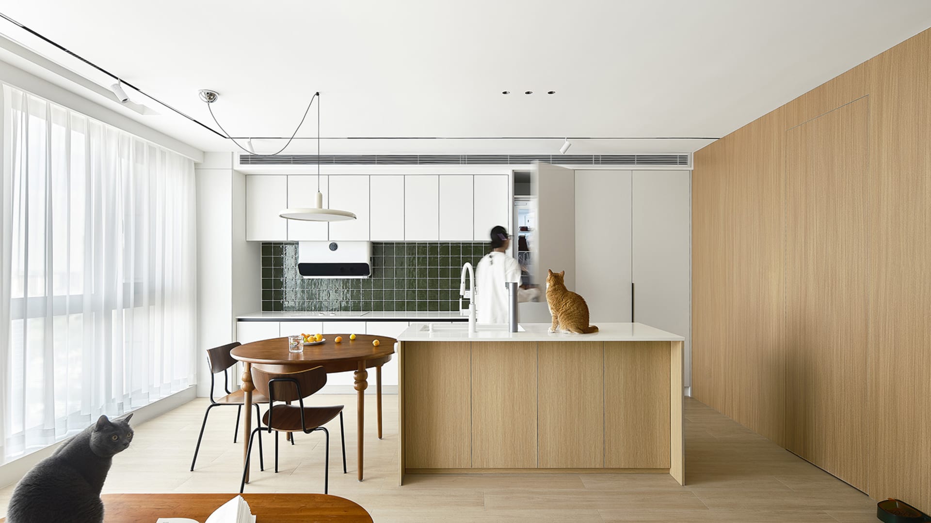 A modern residential kitchen featuring wooden and laminate finishes with a central island.