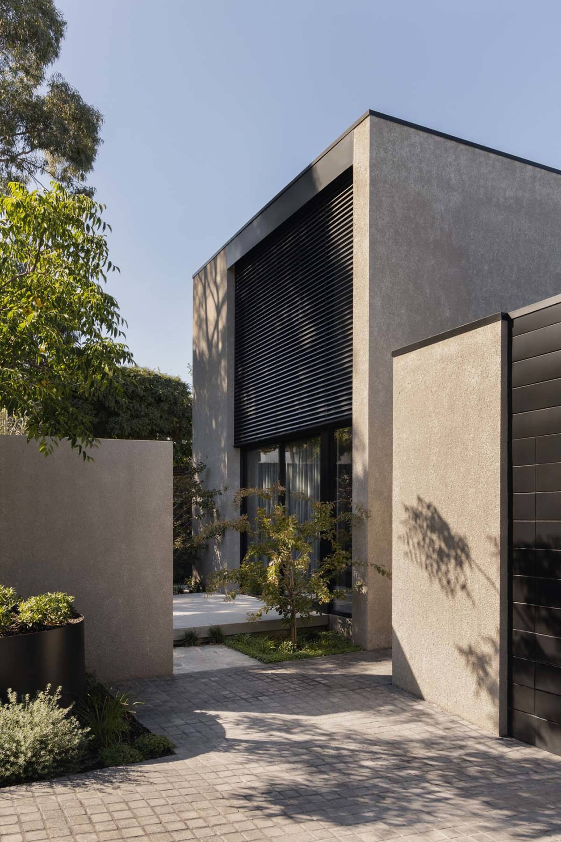 Modern residential entryway featuring concrete and glass materials.