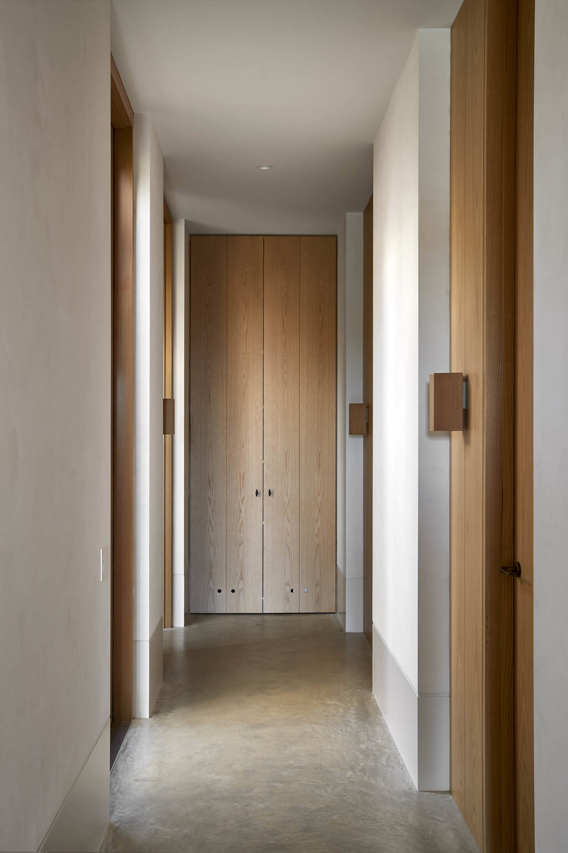 Modern interior design with concrete floor and wooden walls, featuring a minimalist corridor.