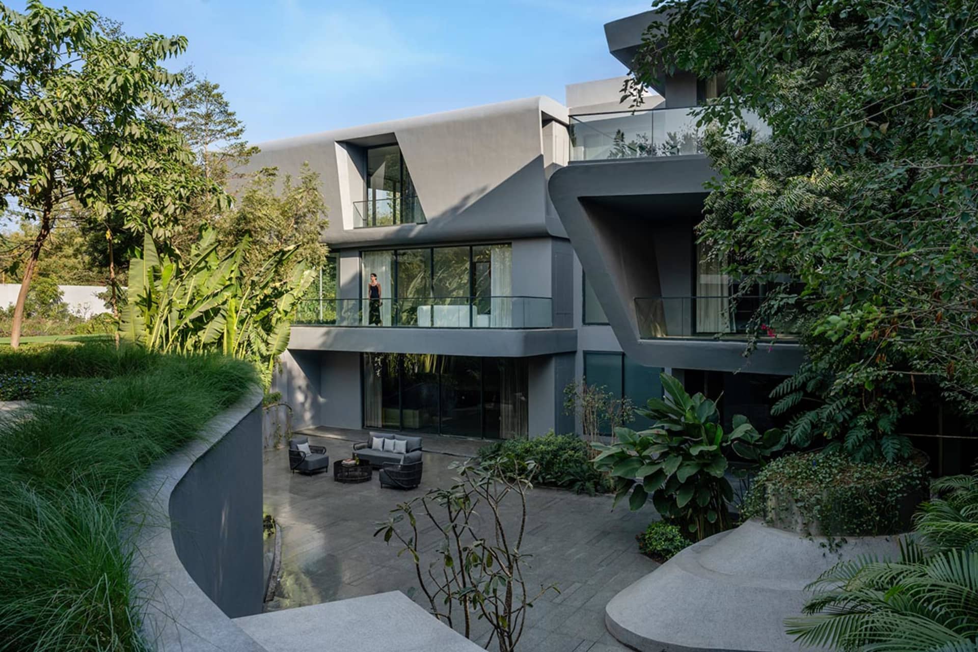 A modern residential living space featuring concrete and glass elements.