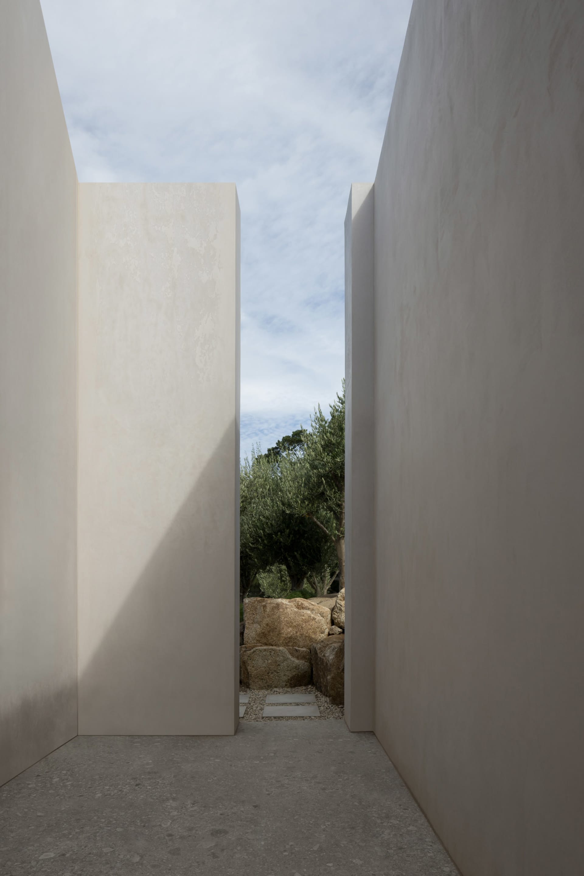 A minimalist architectural design featuring concrete walls and a skylight.