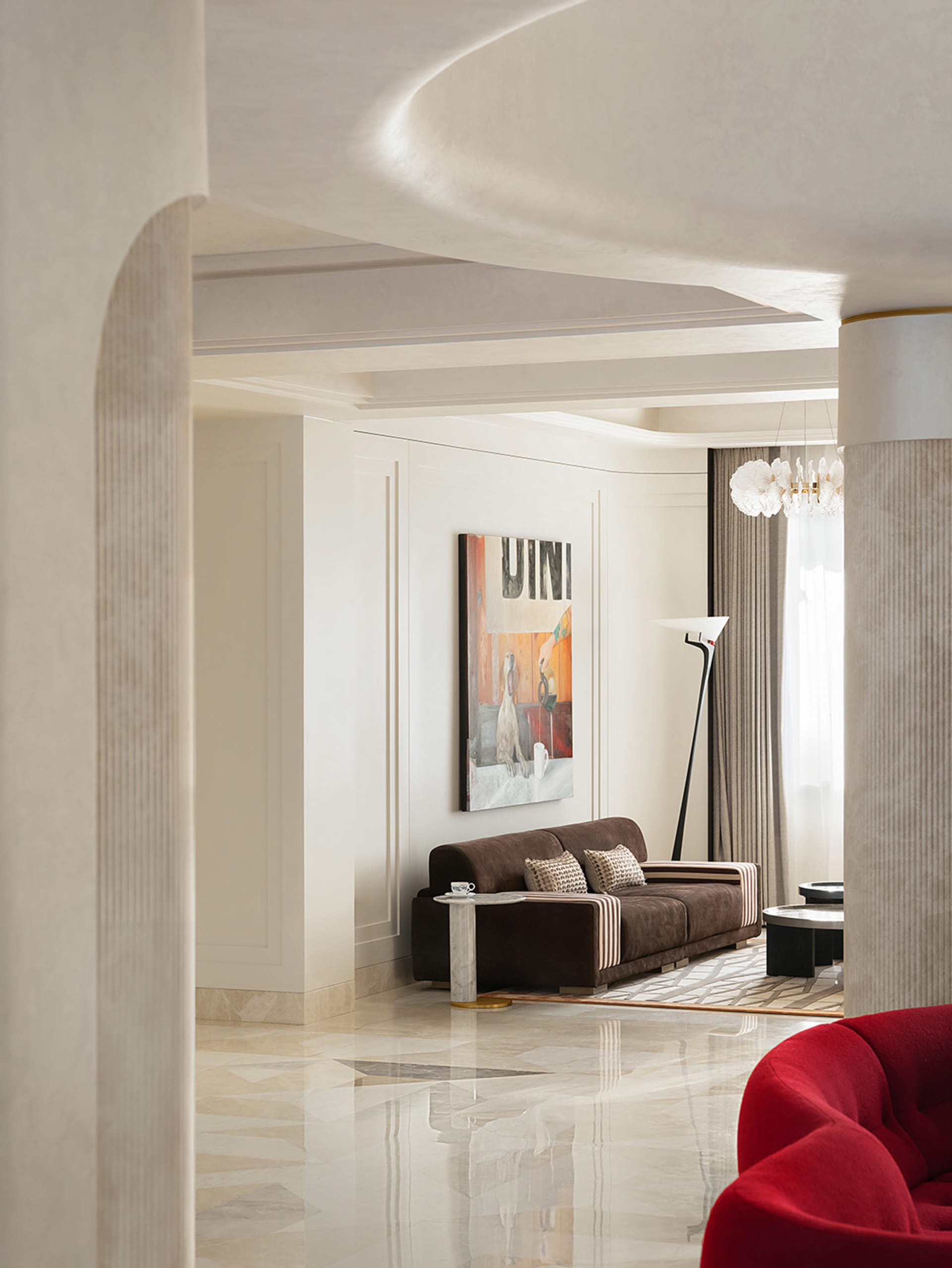 Modern living room with a brown sofa, marble flooring, and a statement artwork on the wall.