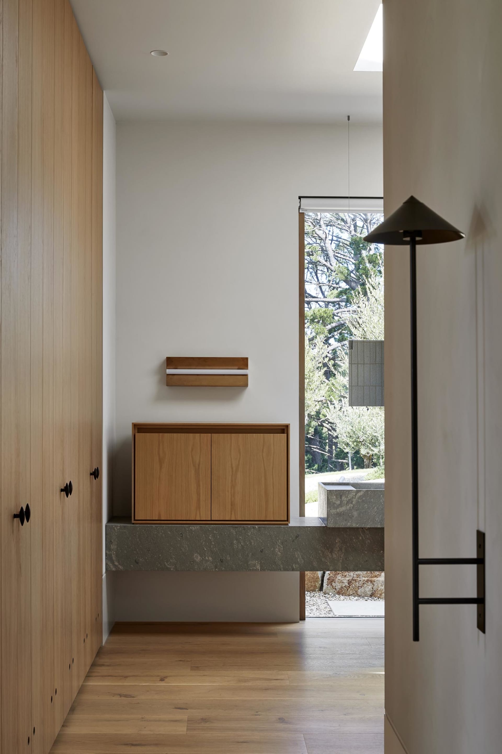 Modern residential entryway featuring wooden cabinets and a marble platform.