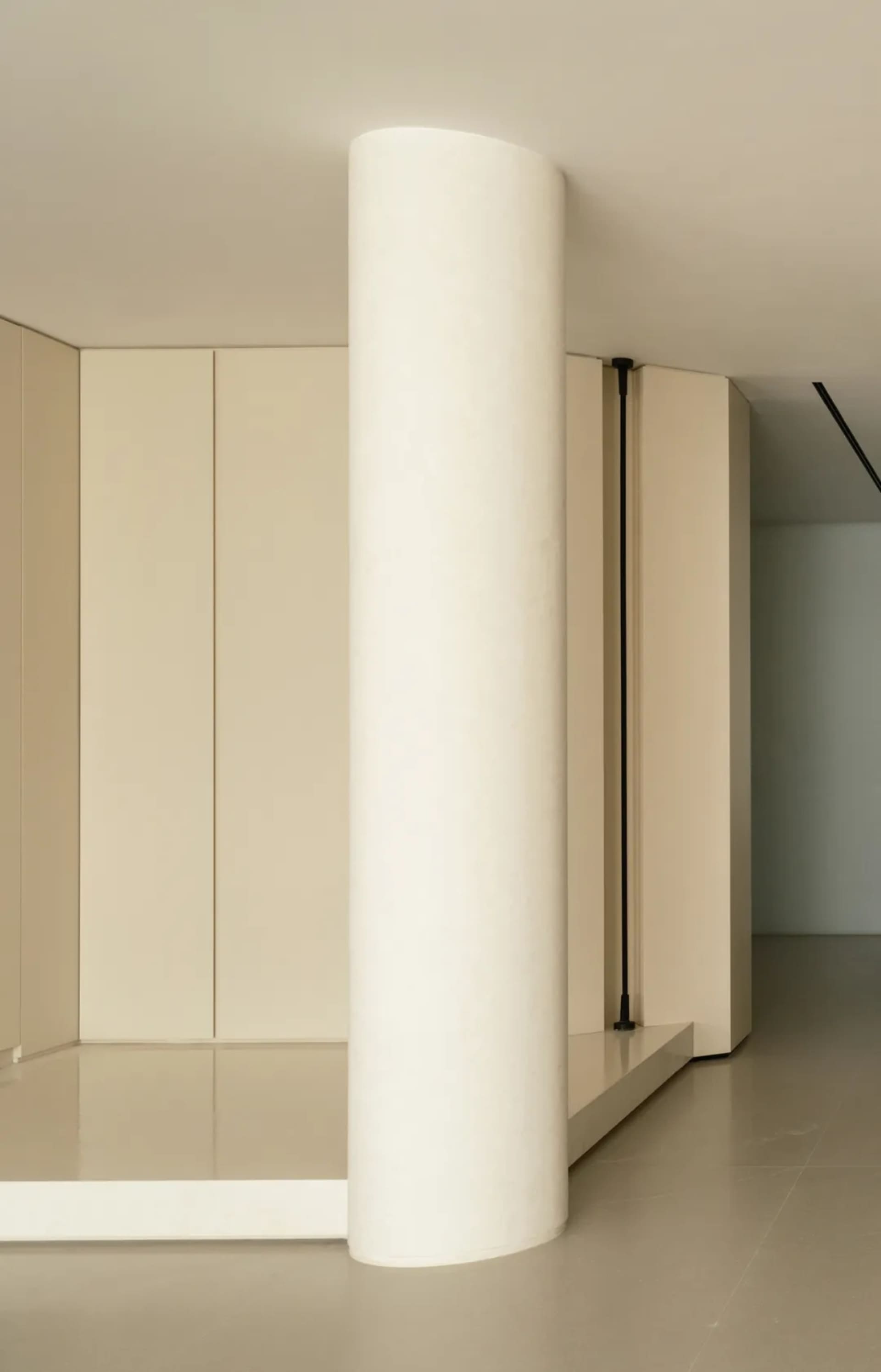 A modern, minimalist bedroom with concrete flooring and minimal furnishings.