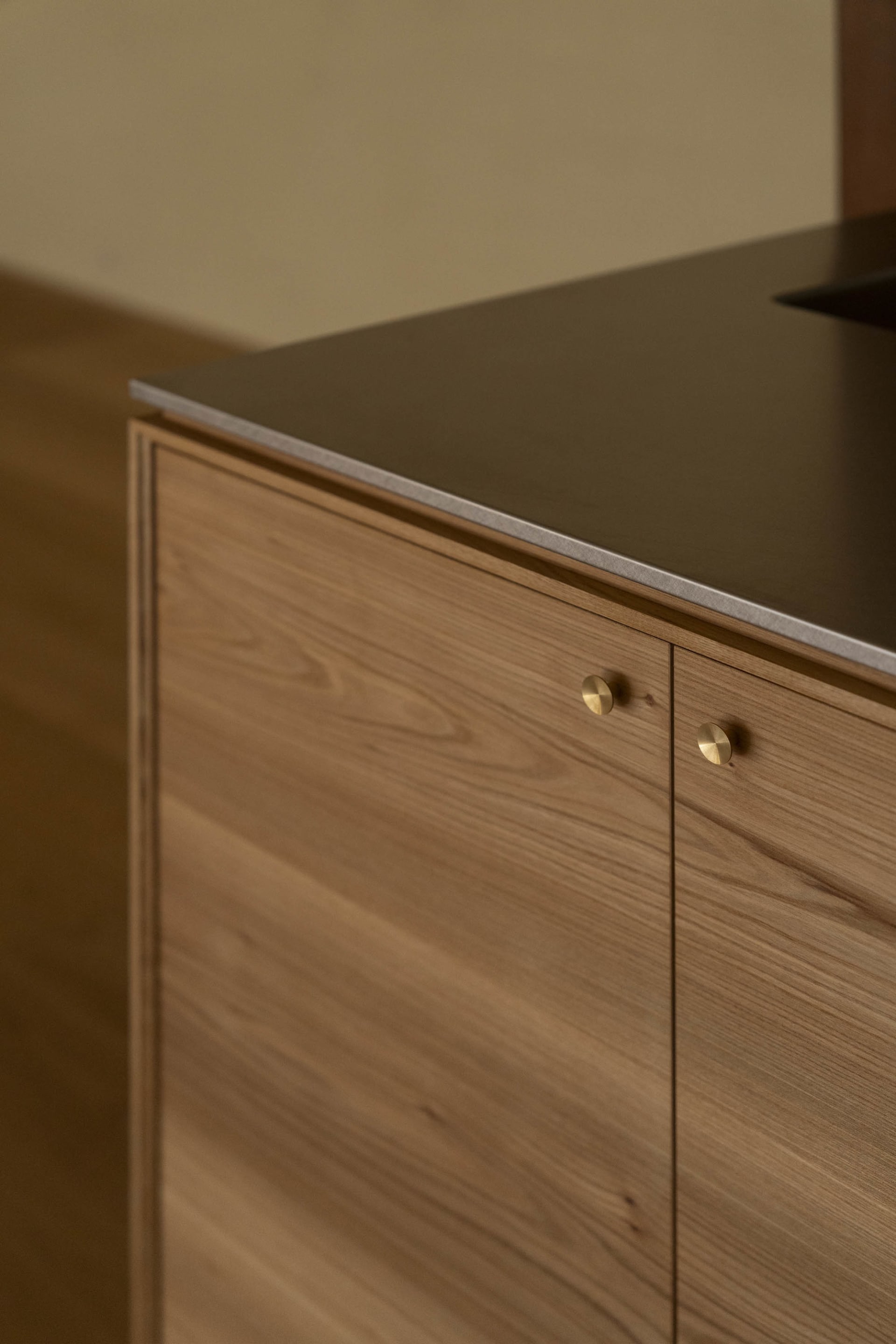 Modern minimalist kitchen featuring wooden cabinetry and a sleek, minimalist design.