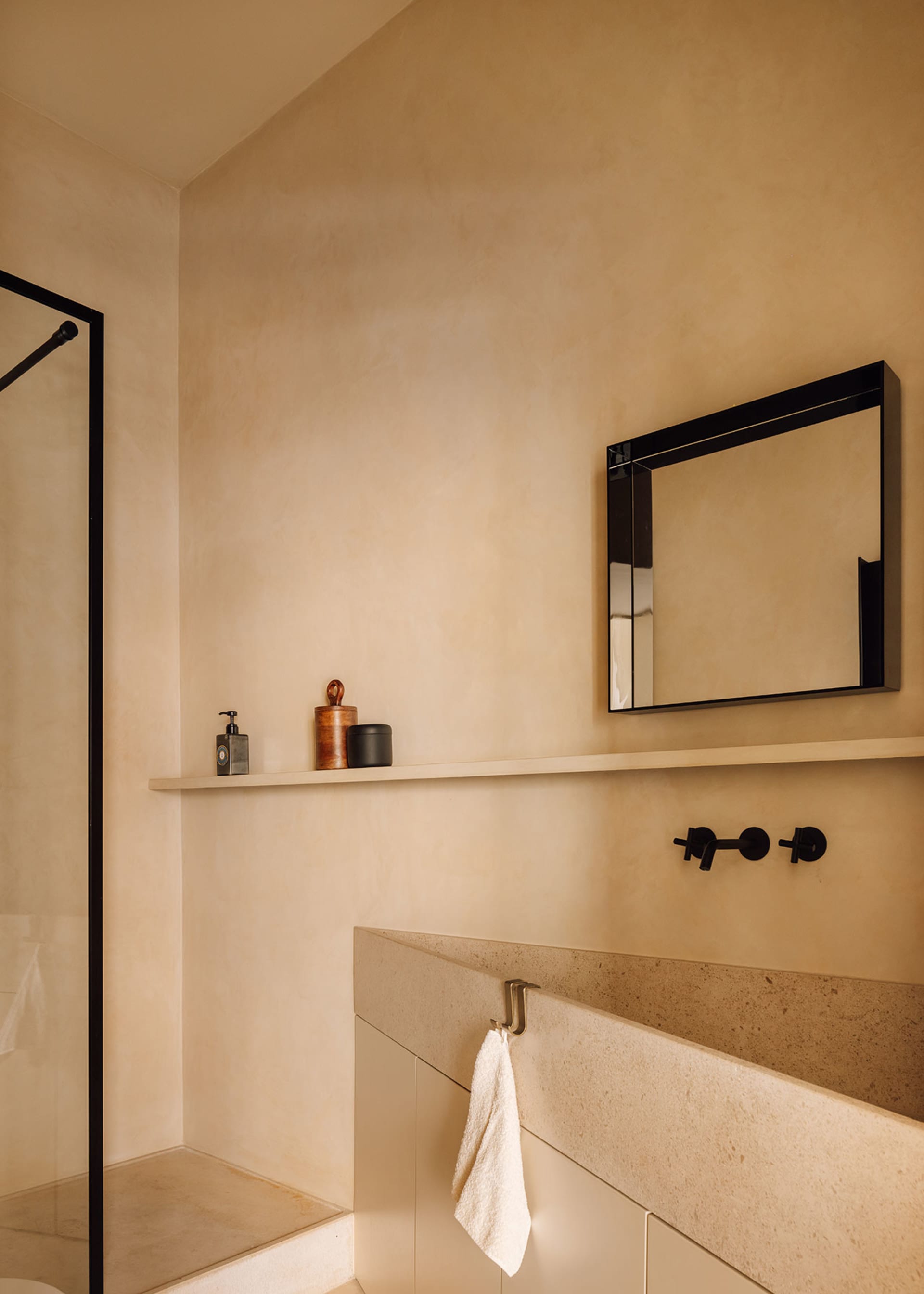 A minimalist bathroom interior featuring concrete and wood elements.