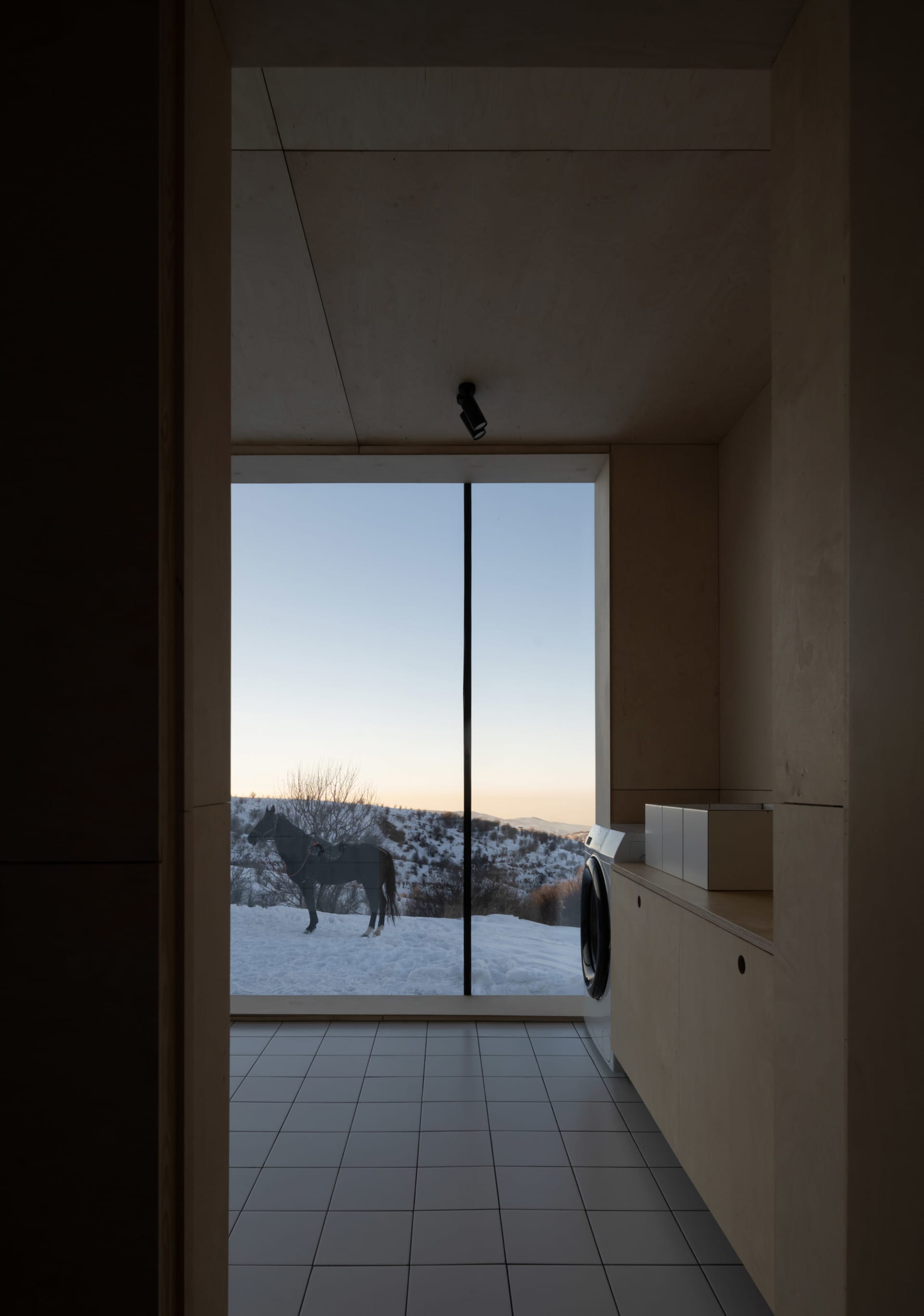 A minimalist interior design featuring a wood floor and floor-to-ceiling window.