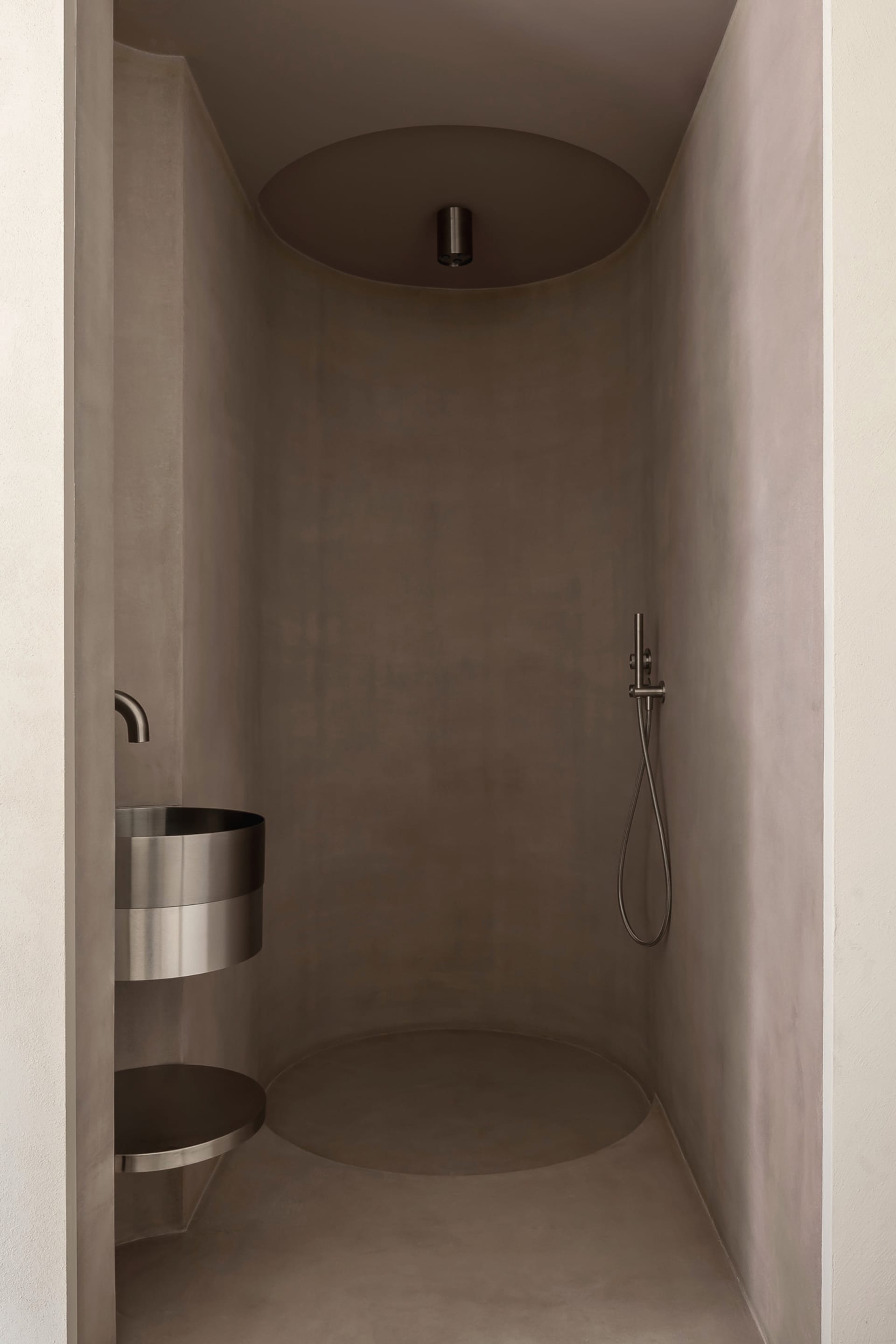 Modern bathroom with concrete walls and floor, minimalist design.
