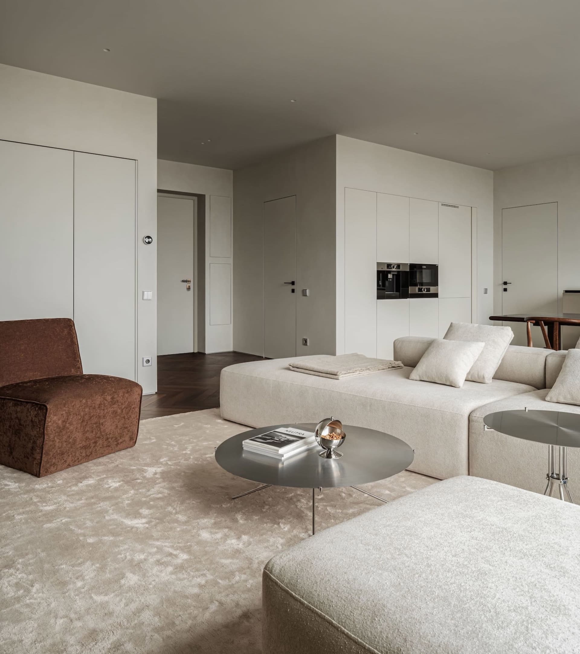 Modern living room with a minimalistic design featuring a taupe, ecru, white, and grey color scheme.
