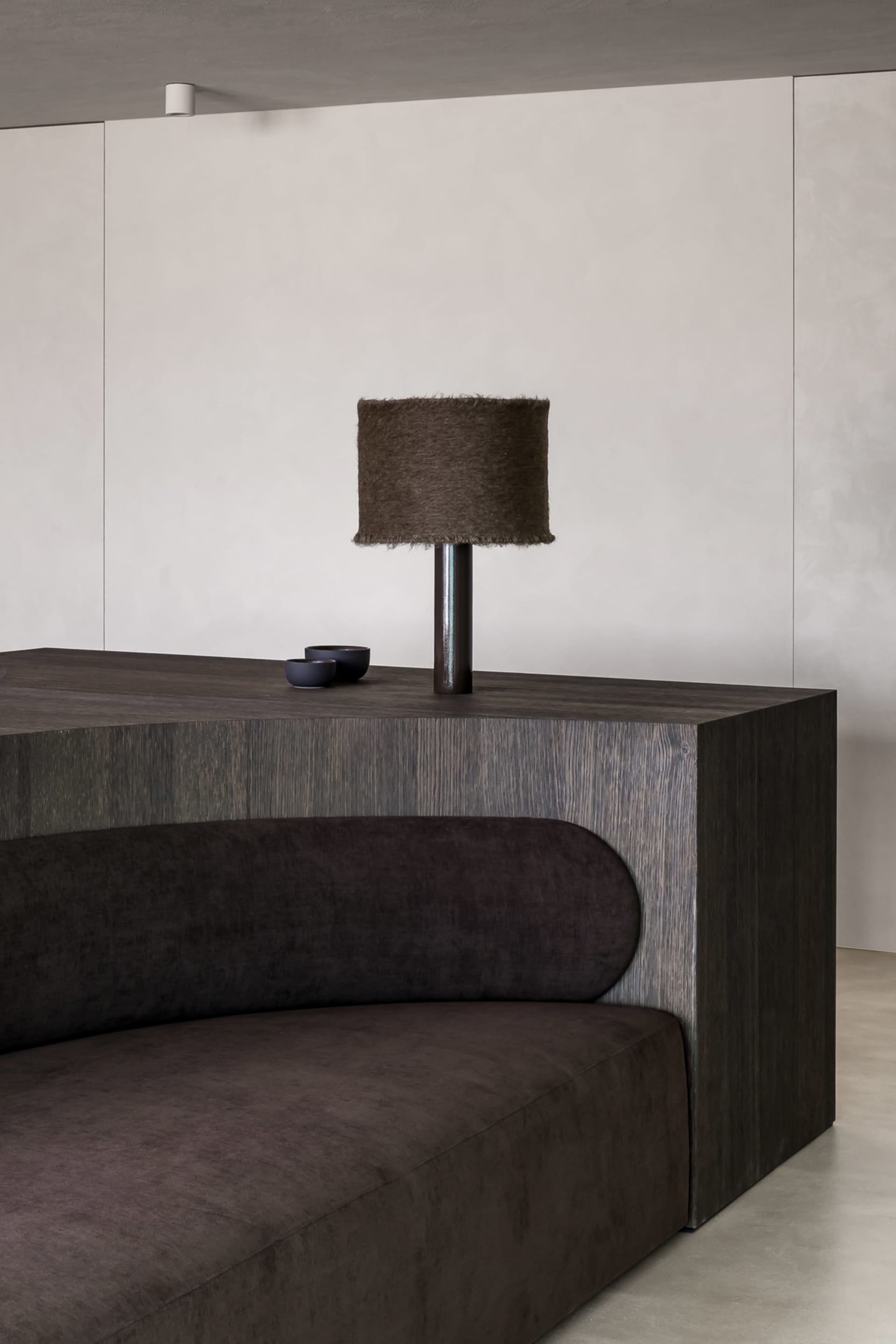 A modern living room featuring a wooden sideboard and a fabric sofa.