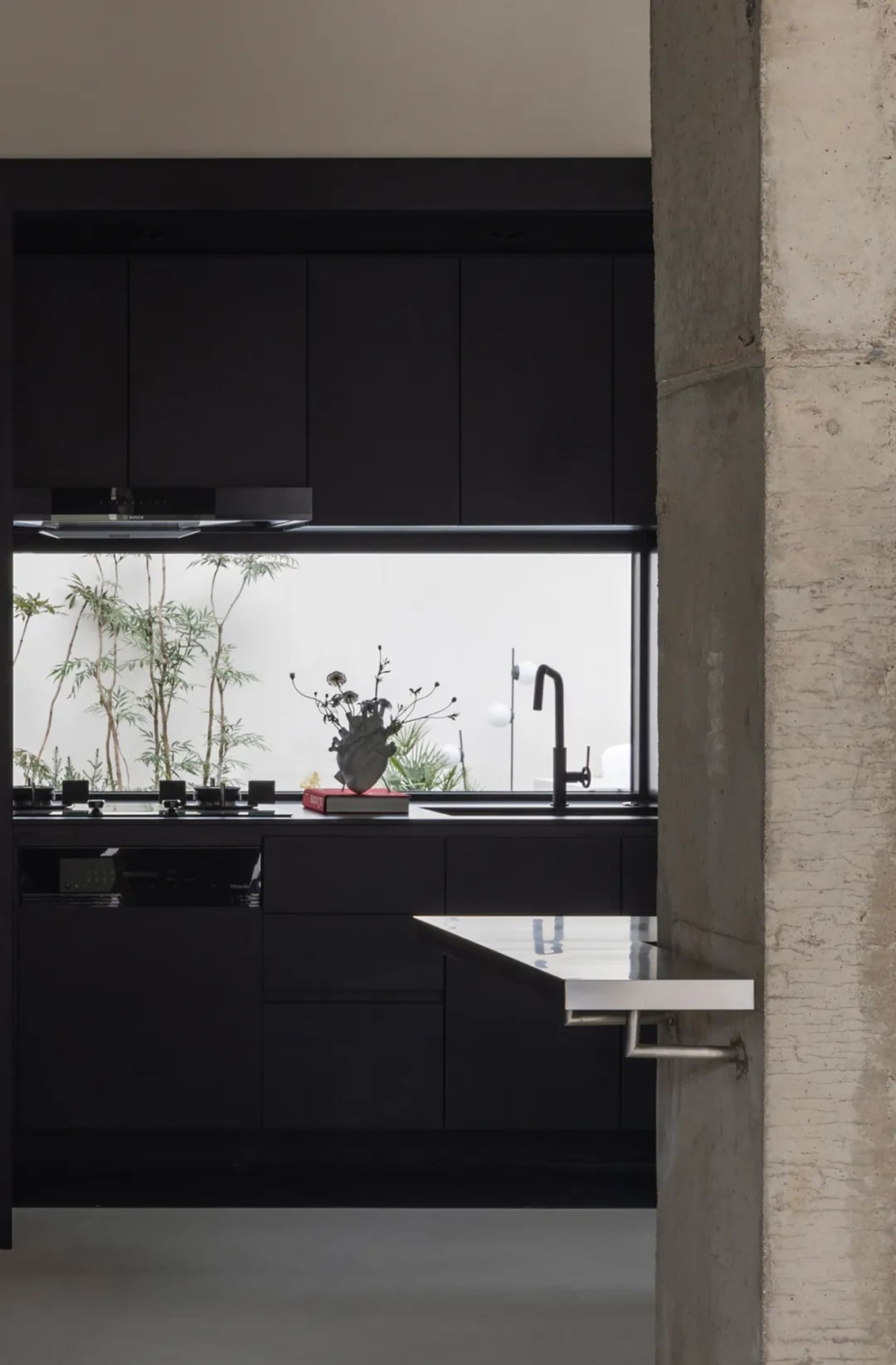 Modern industrial kitchen with black cabinets and metallic accents