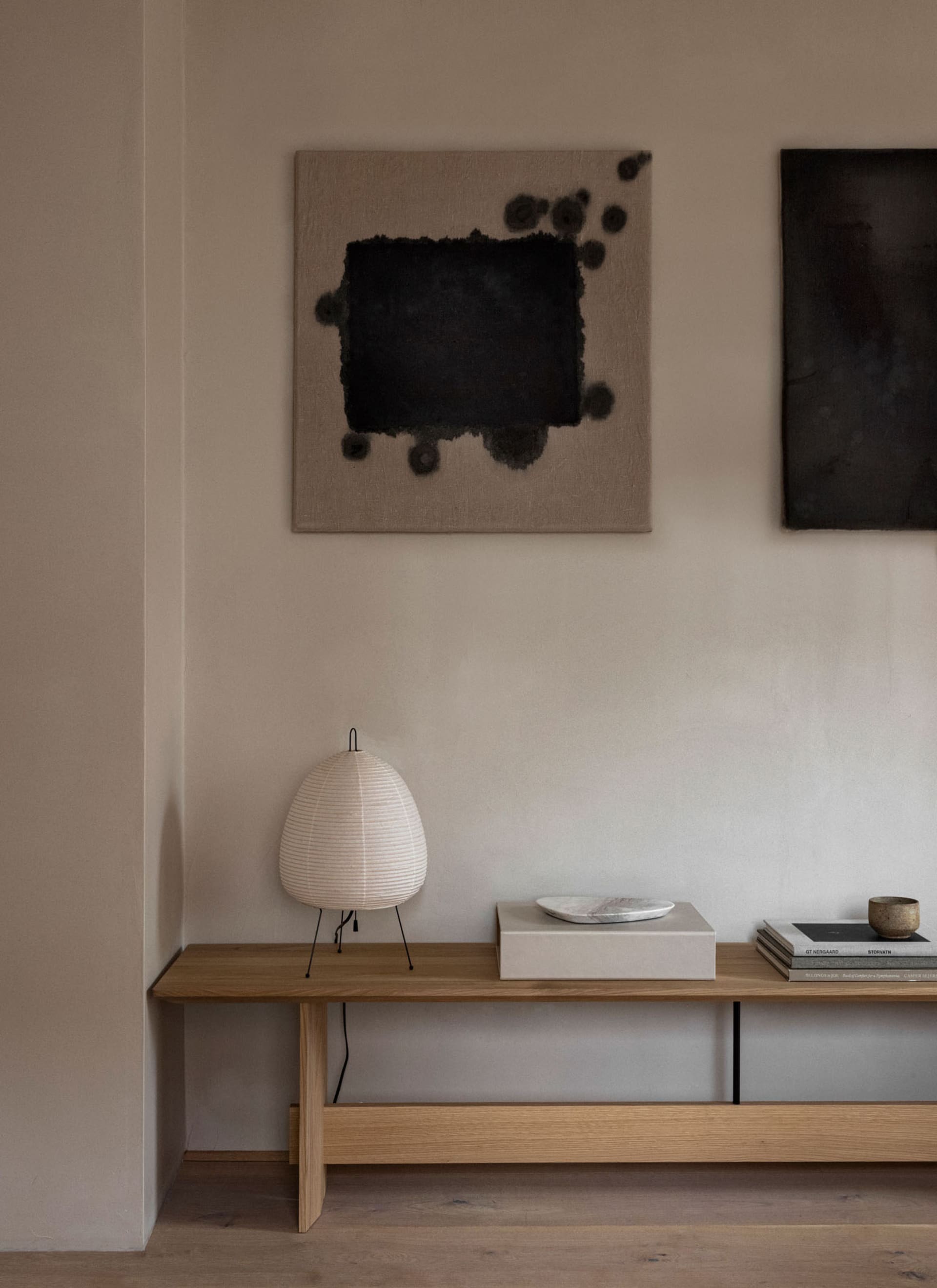 Minimalist living room featuring wood furniture and abstract art on the walls.