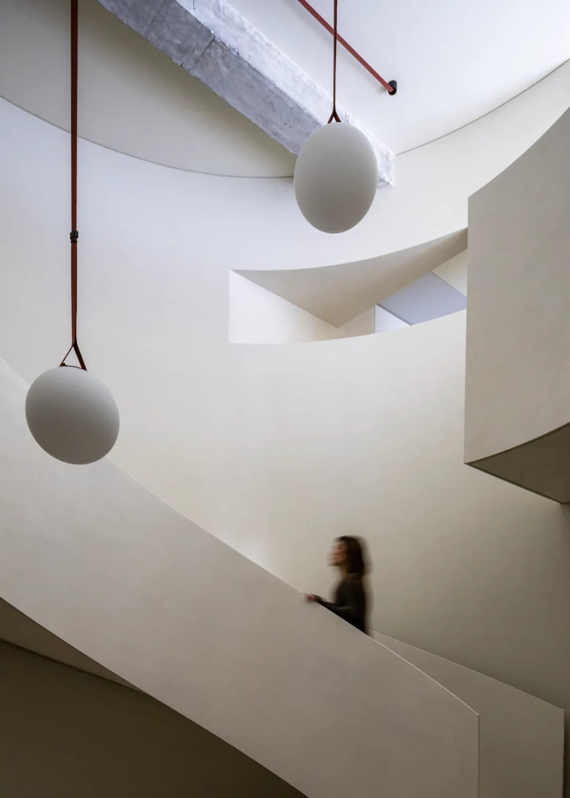 Modern, minimalist staircase with concrete walls and floating light installations.