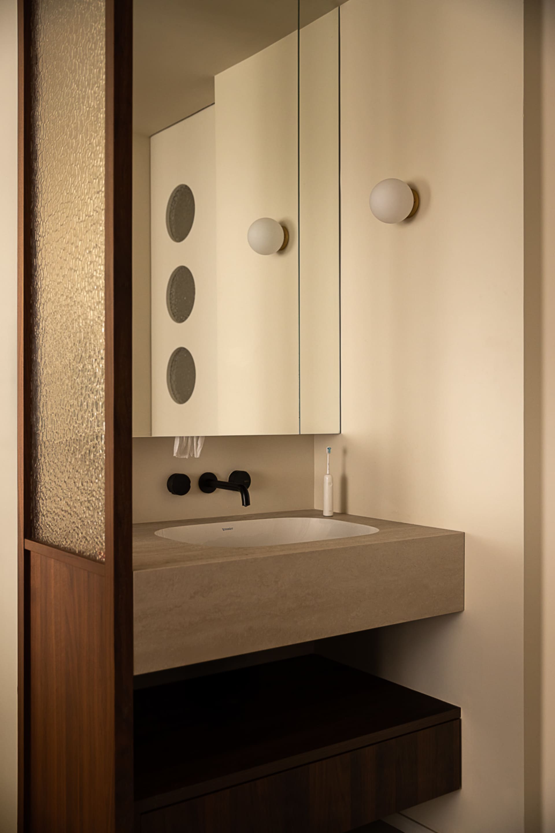 Modern, industrial-style bathroom featuring a minimalist design with a concrete sink.
