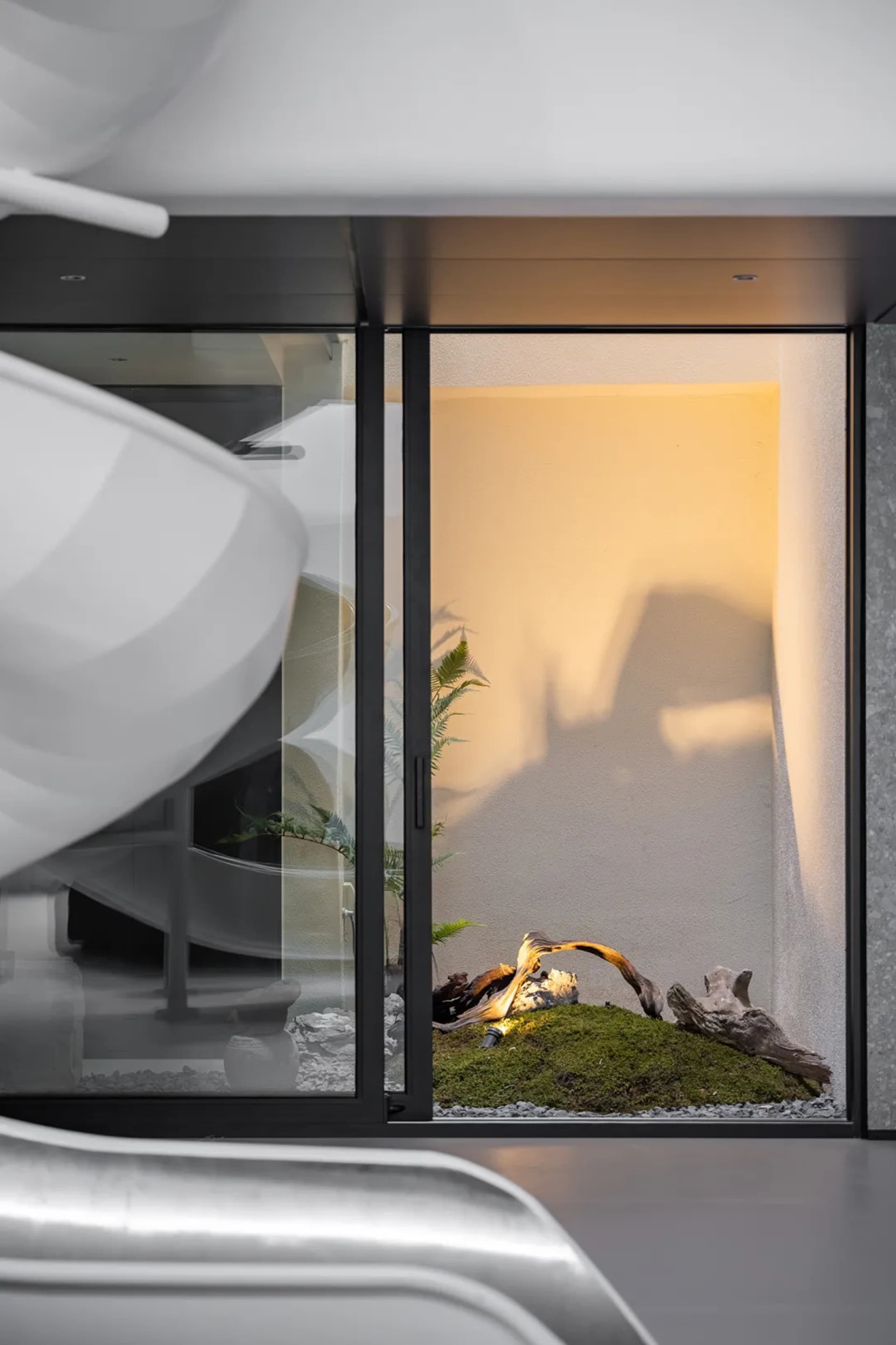 Interior design of a modern bathroom featuring glass walls and a minimalist design.