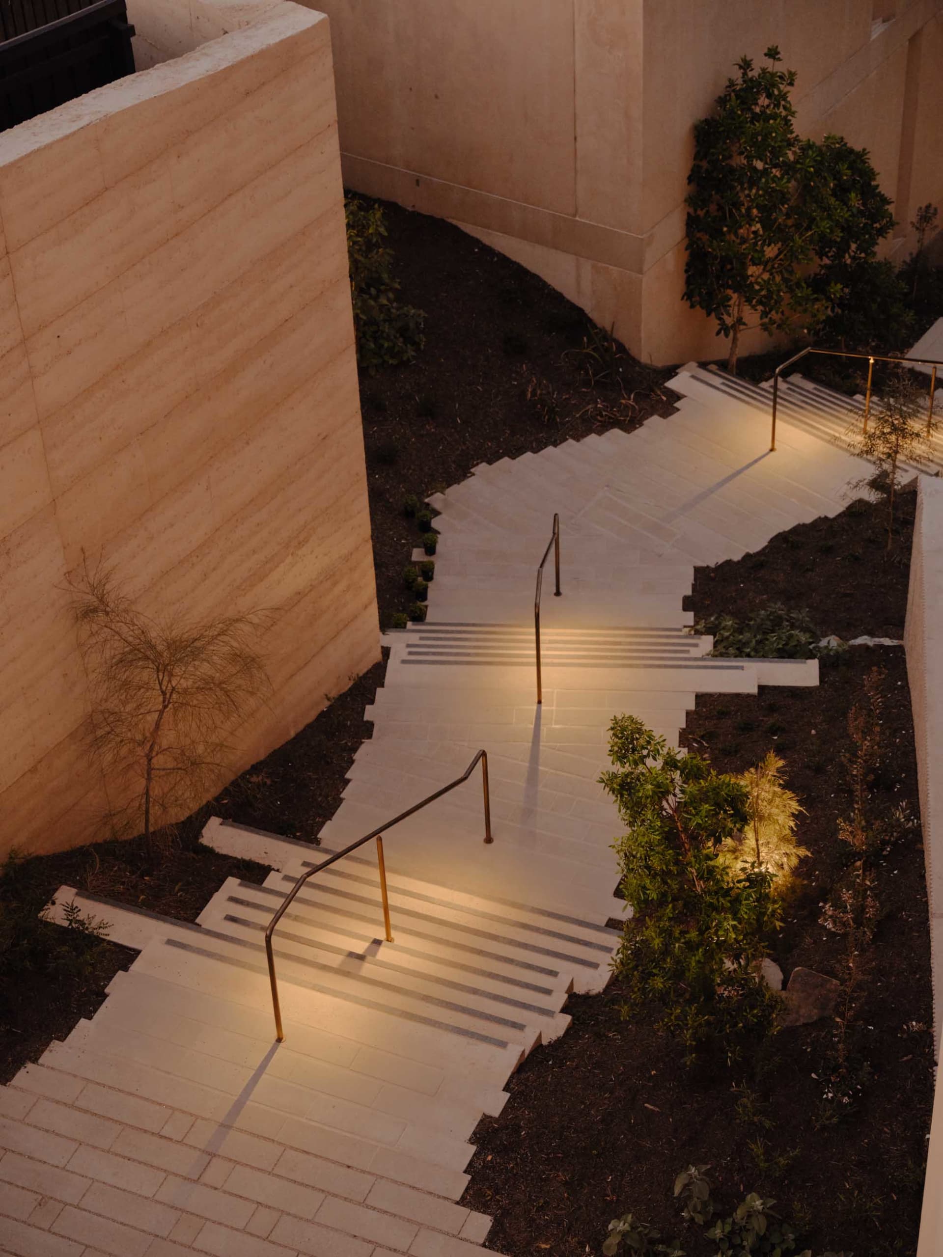 Concrete stairs with handrails in an architectural setting.