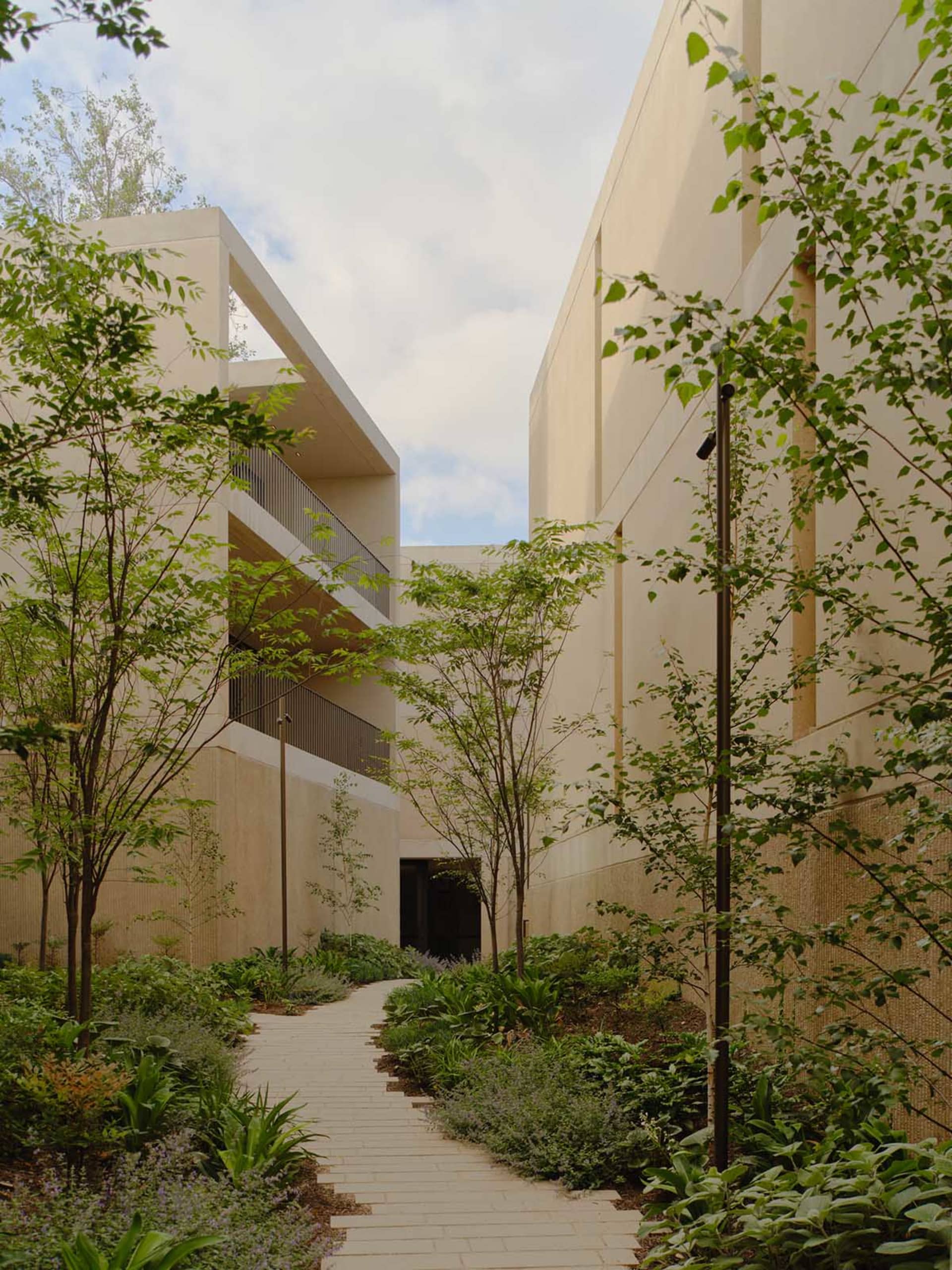 Modern building exterior with concrete walls and green landscaping.