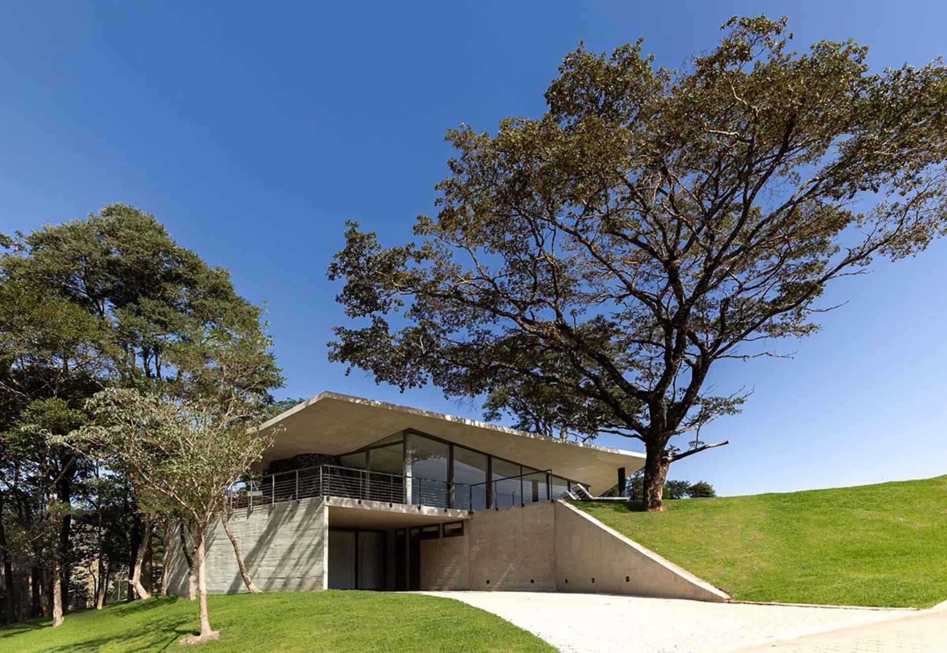 A modern house featuring a concrete exterior and glass windows.